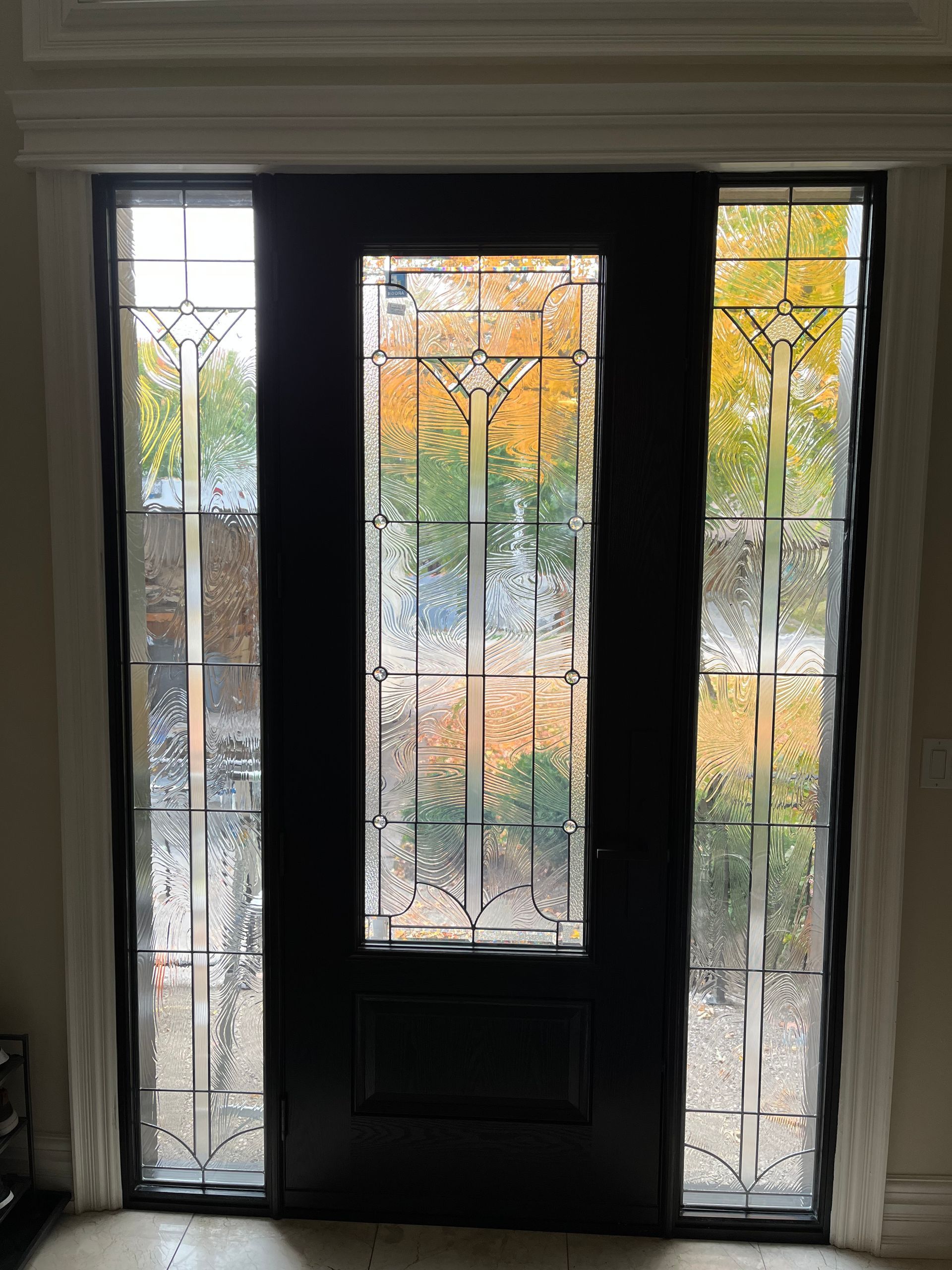 A black door with stained glass windows in a room.