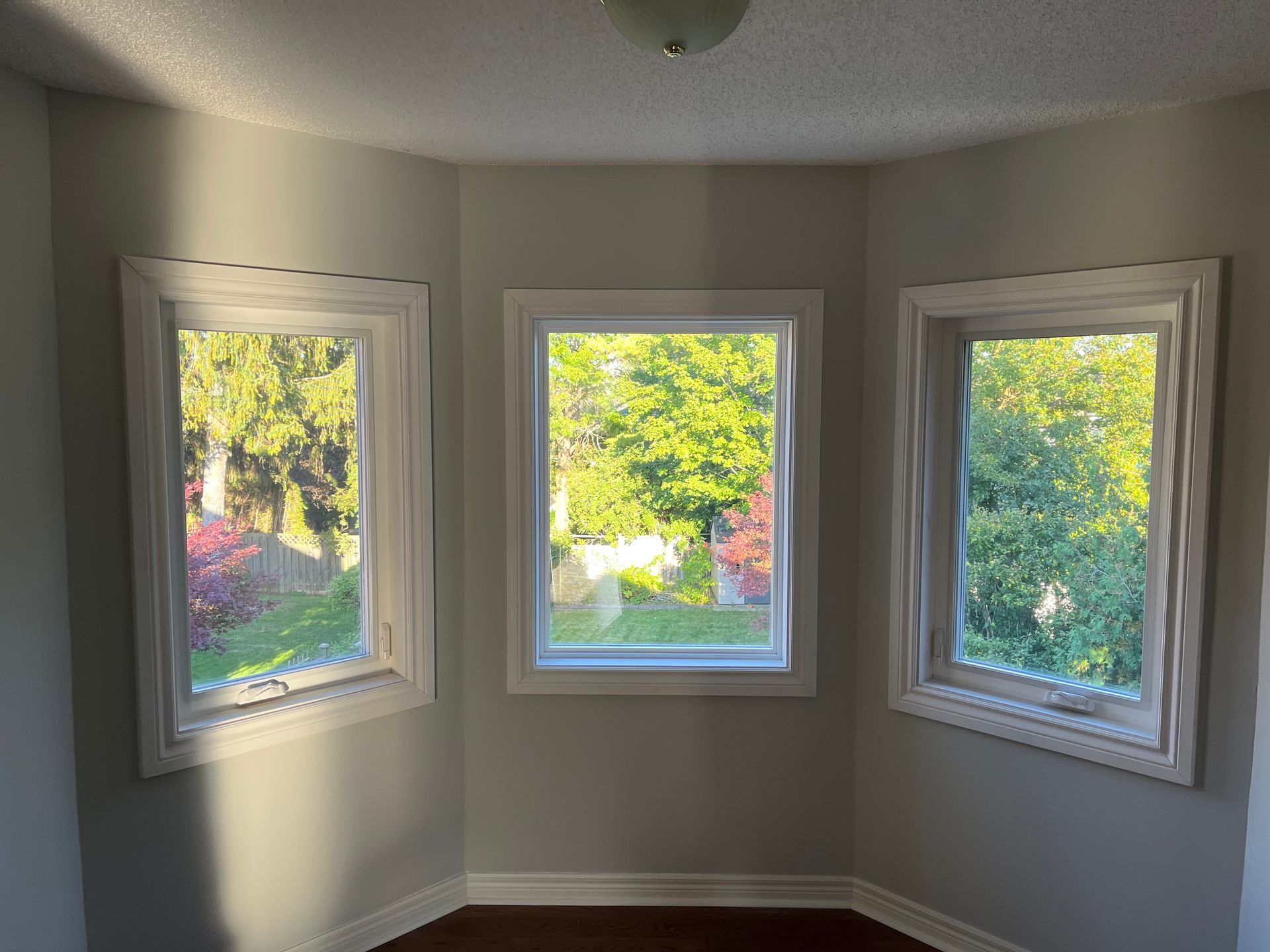 There are three windows in the corner of the room.
