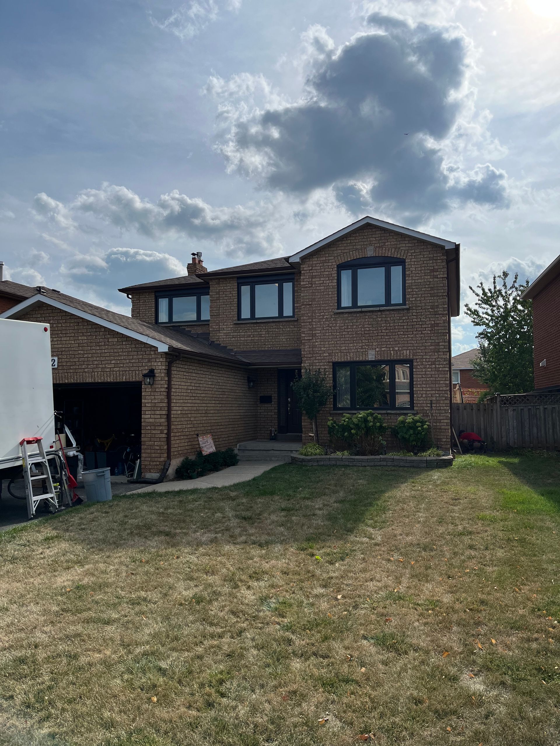 A large brick house with a white truck parked in front of it.