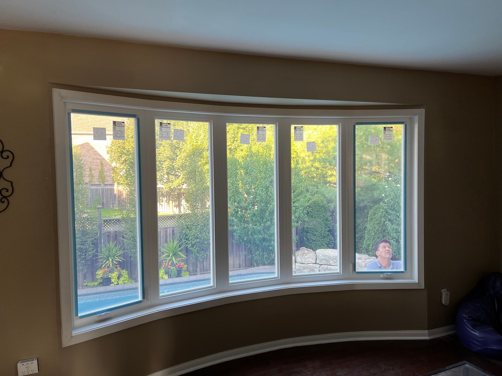 A living room with a large bay window and a blue chair.