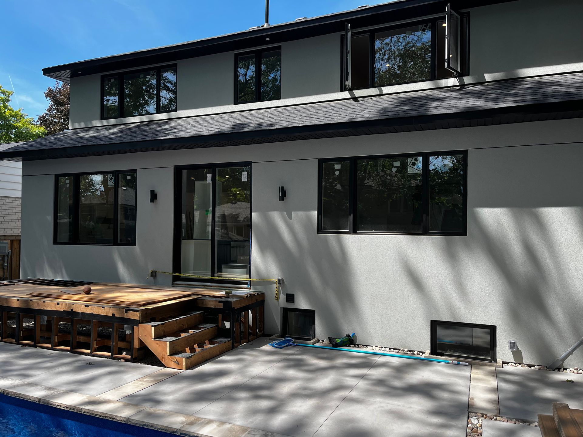 The back of a house with a swimming pool in front of it.