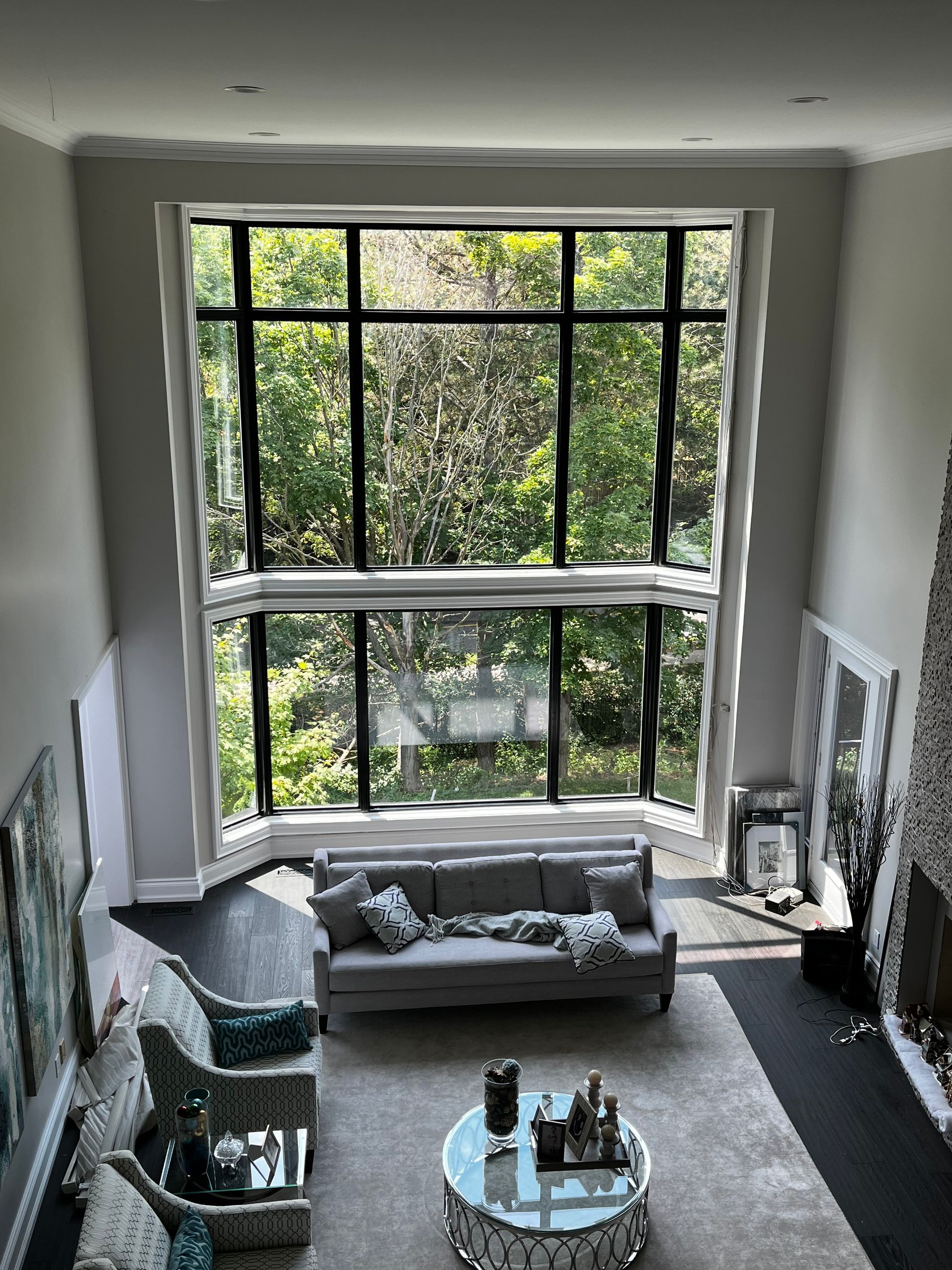 A living room with a couch , chairs , and a large window.