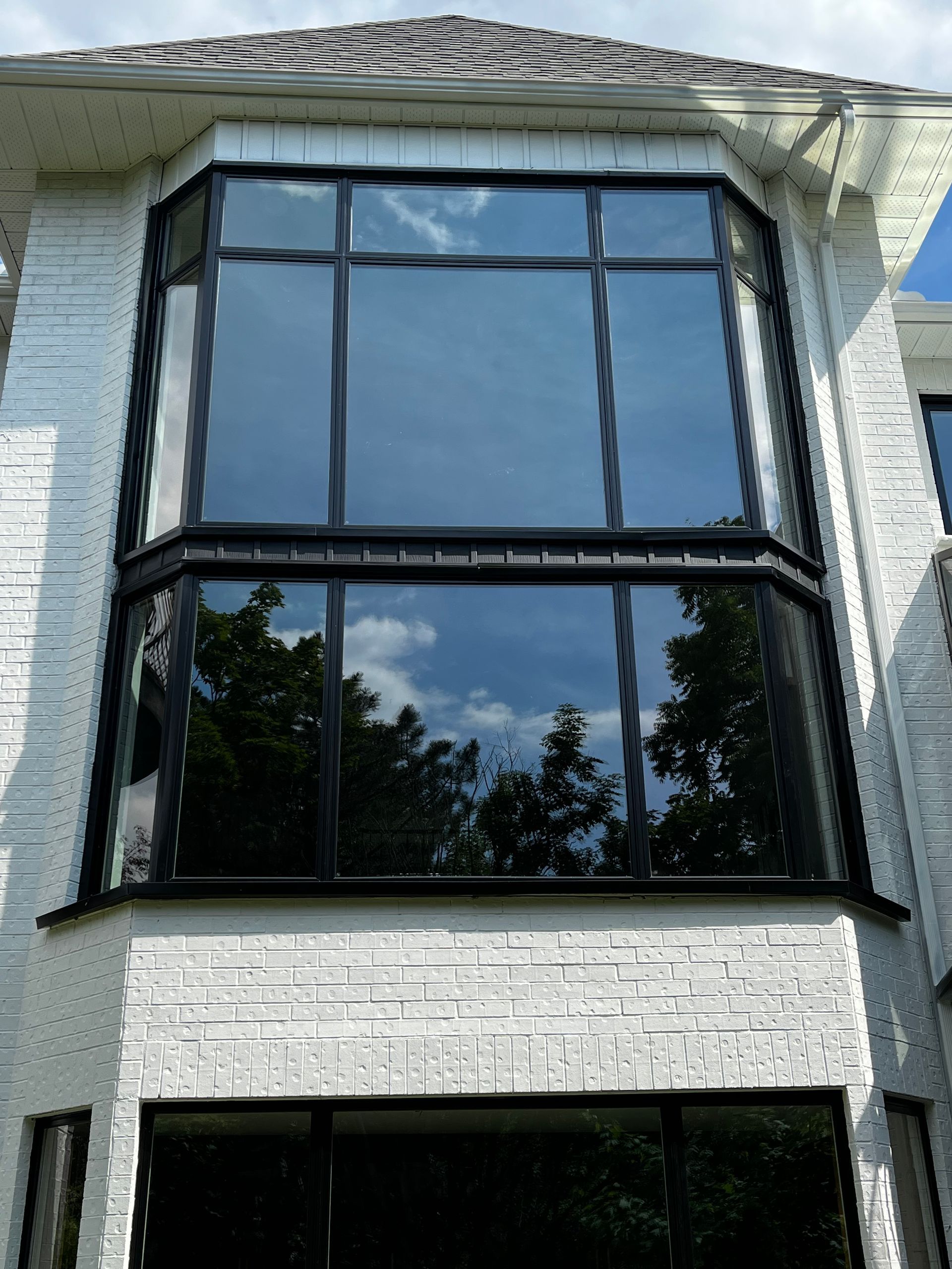 A white brick building with a large bay window