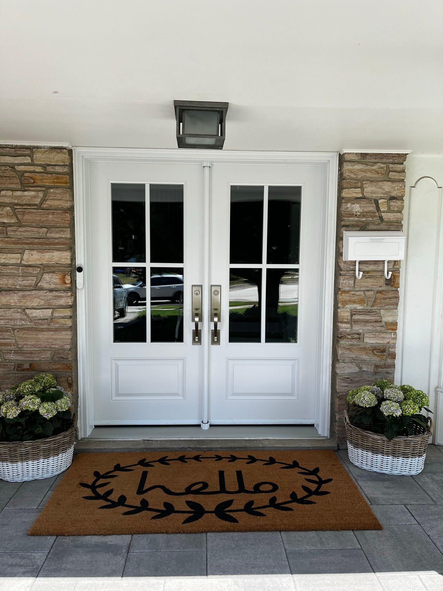A white door with a hello mat in front of it