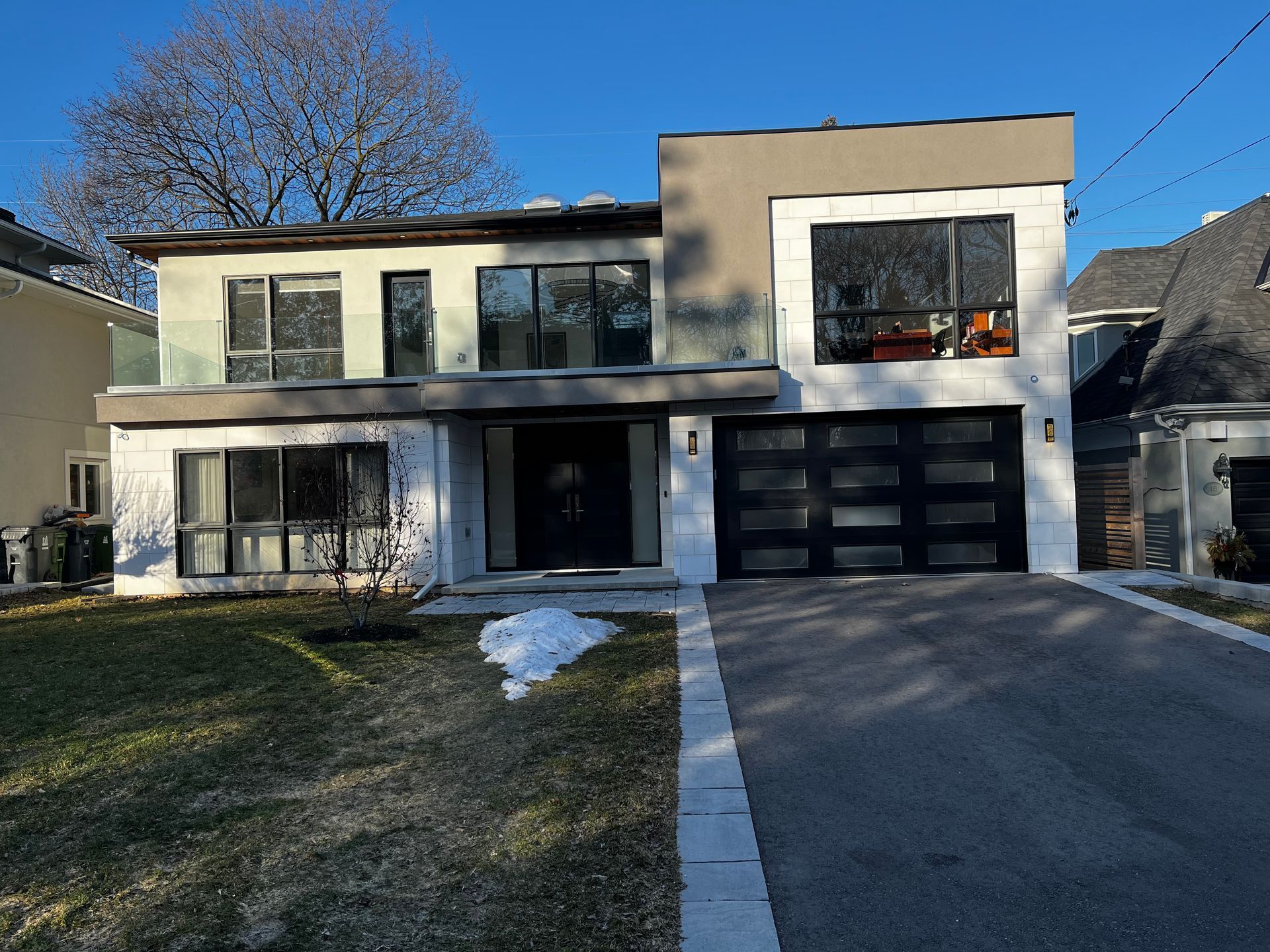 A modern house with a large garage door and a lot of windows.