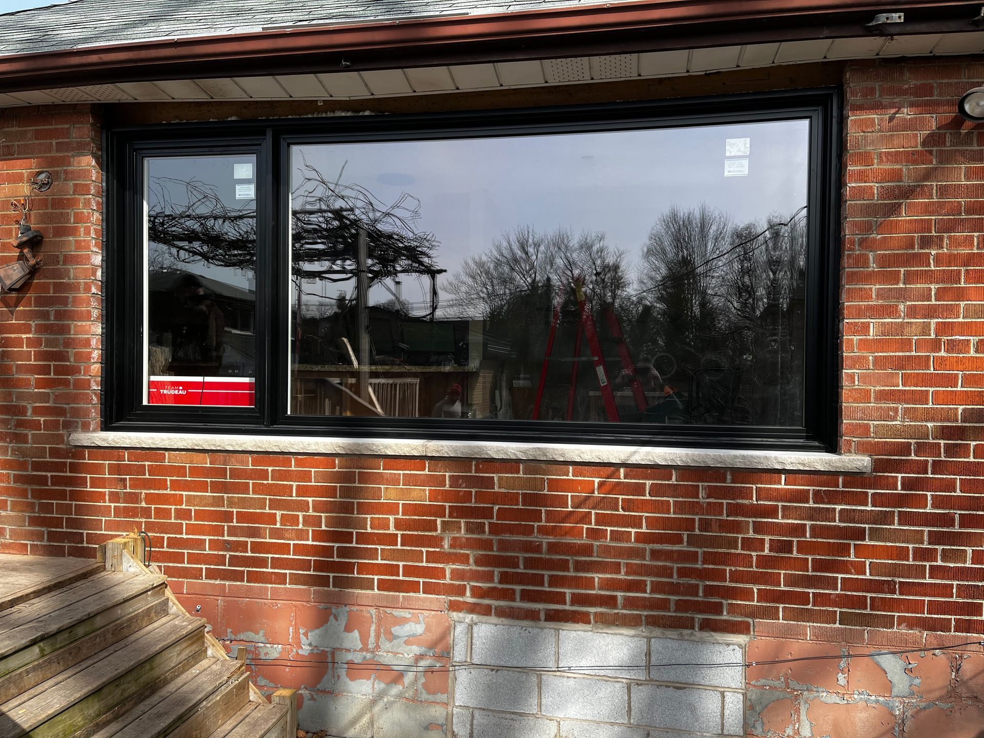 A large window on the side of a brick house.