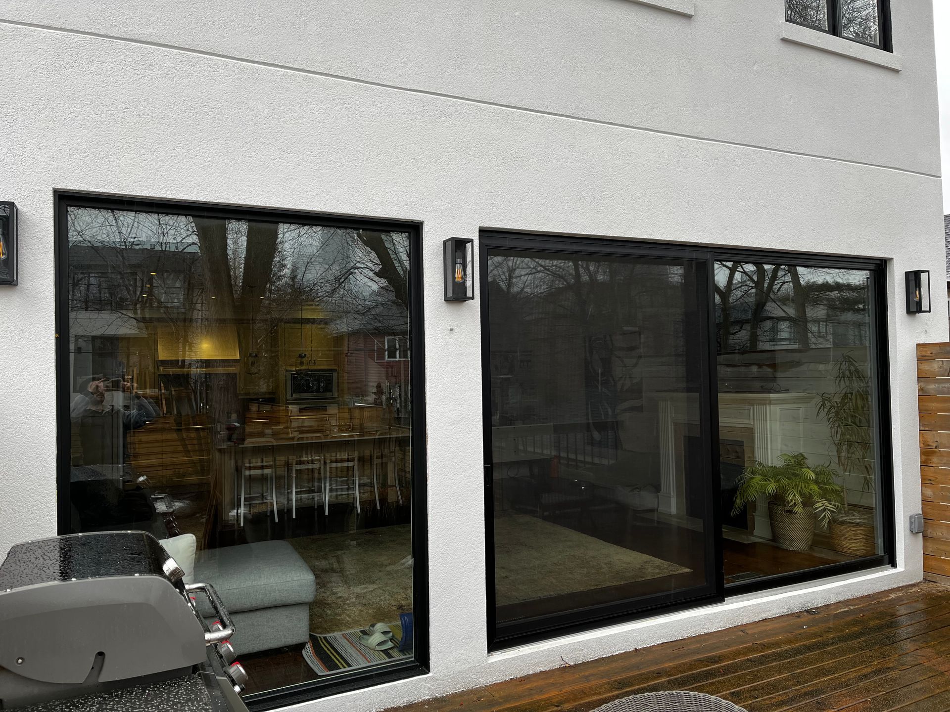A white house with sliding glass doors leading to a patio.