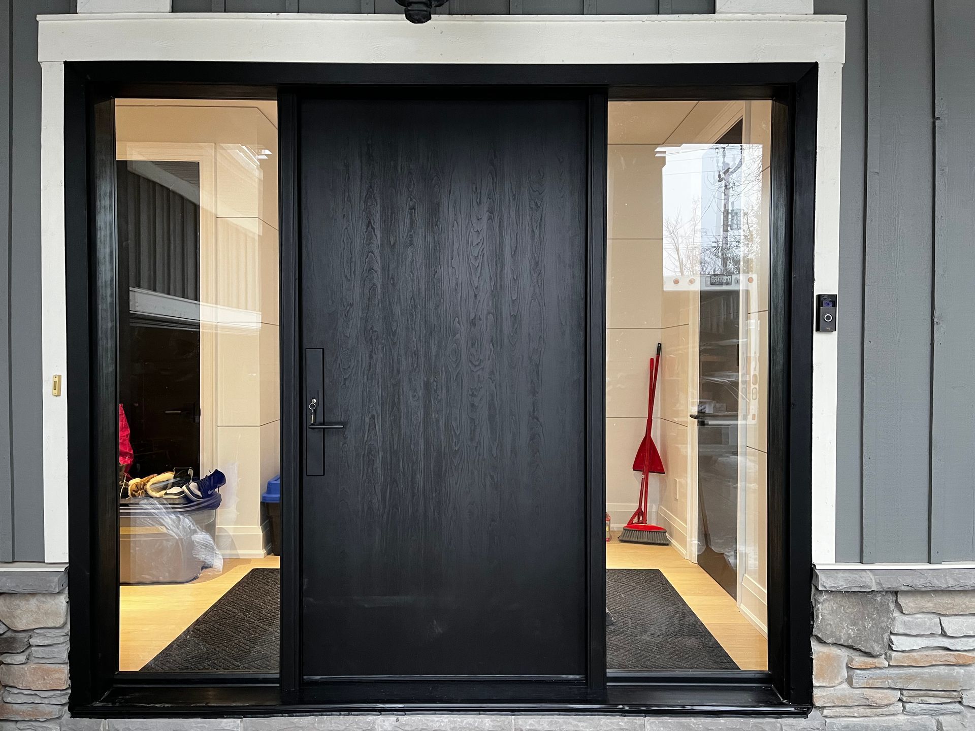 The front door of a house with a black door and glass windows.