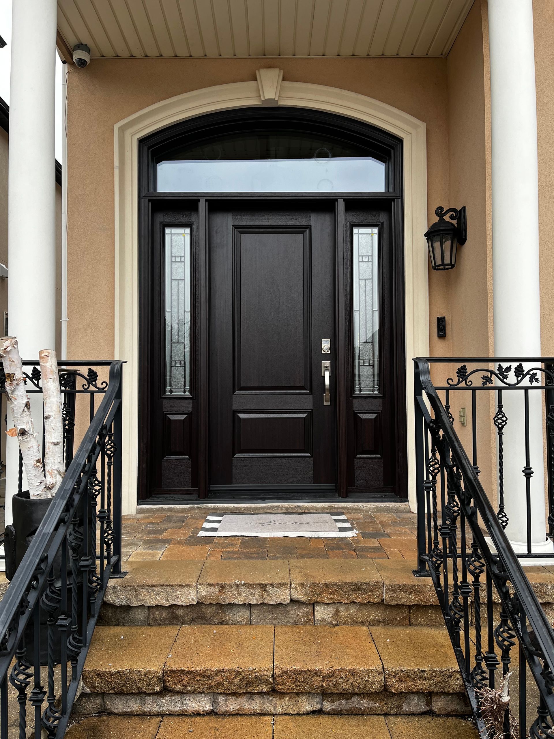 The front door of a house with stairs leading up to it.