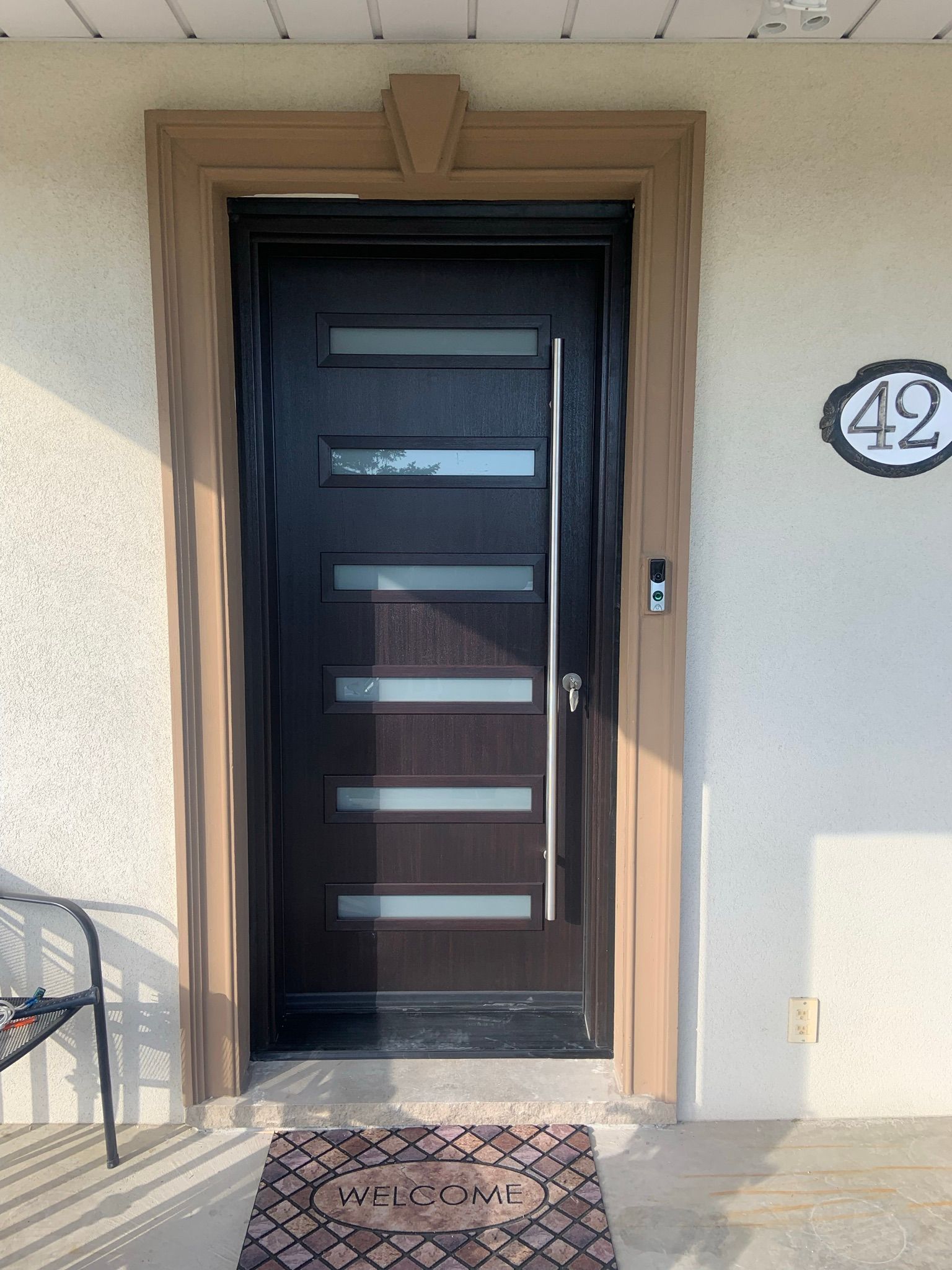The front door of a house with a welcome mat in front of it.