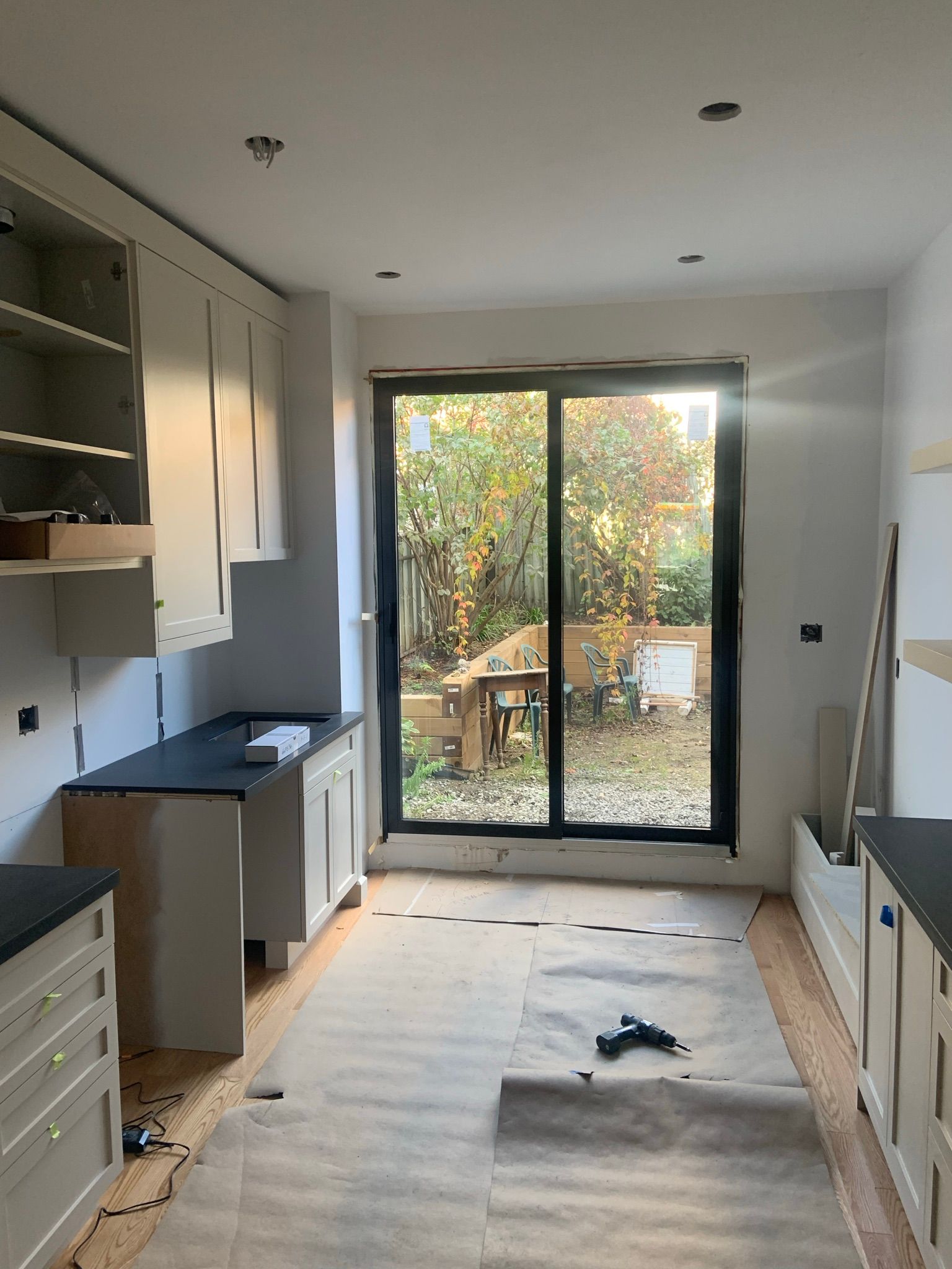 A kitchen with a sliding glass door and white cabinets