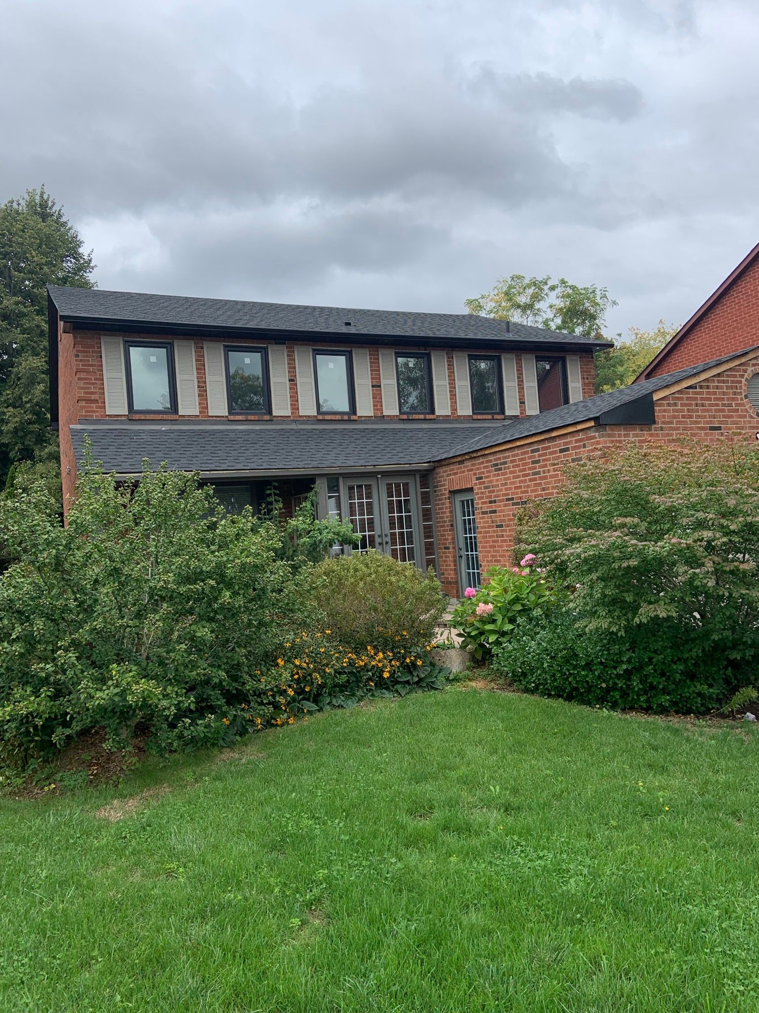 A large brick house with a large lawn in front of it.