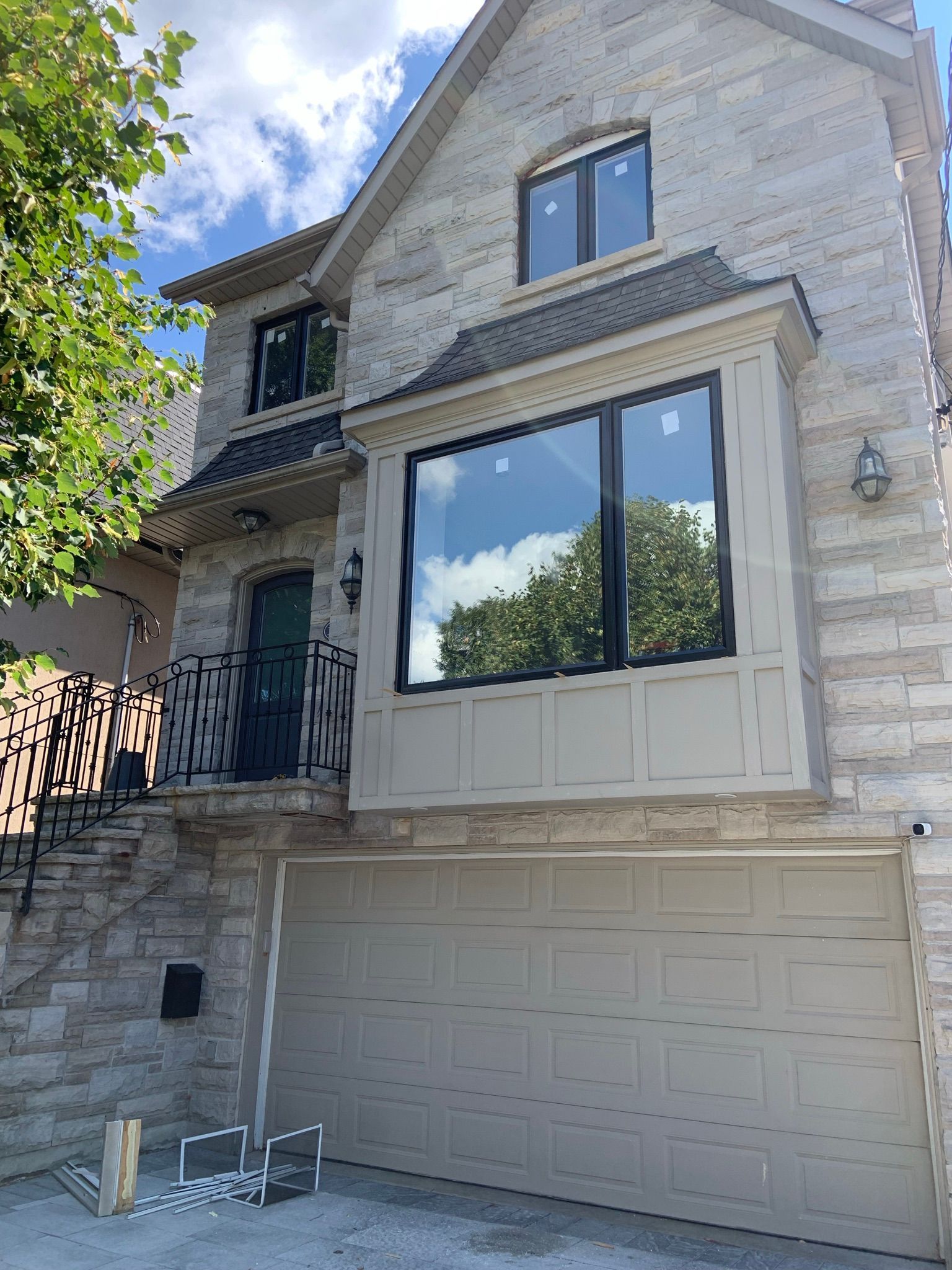 A large brick house with a garage and a large window.