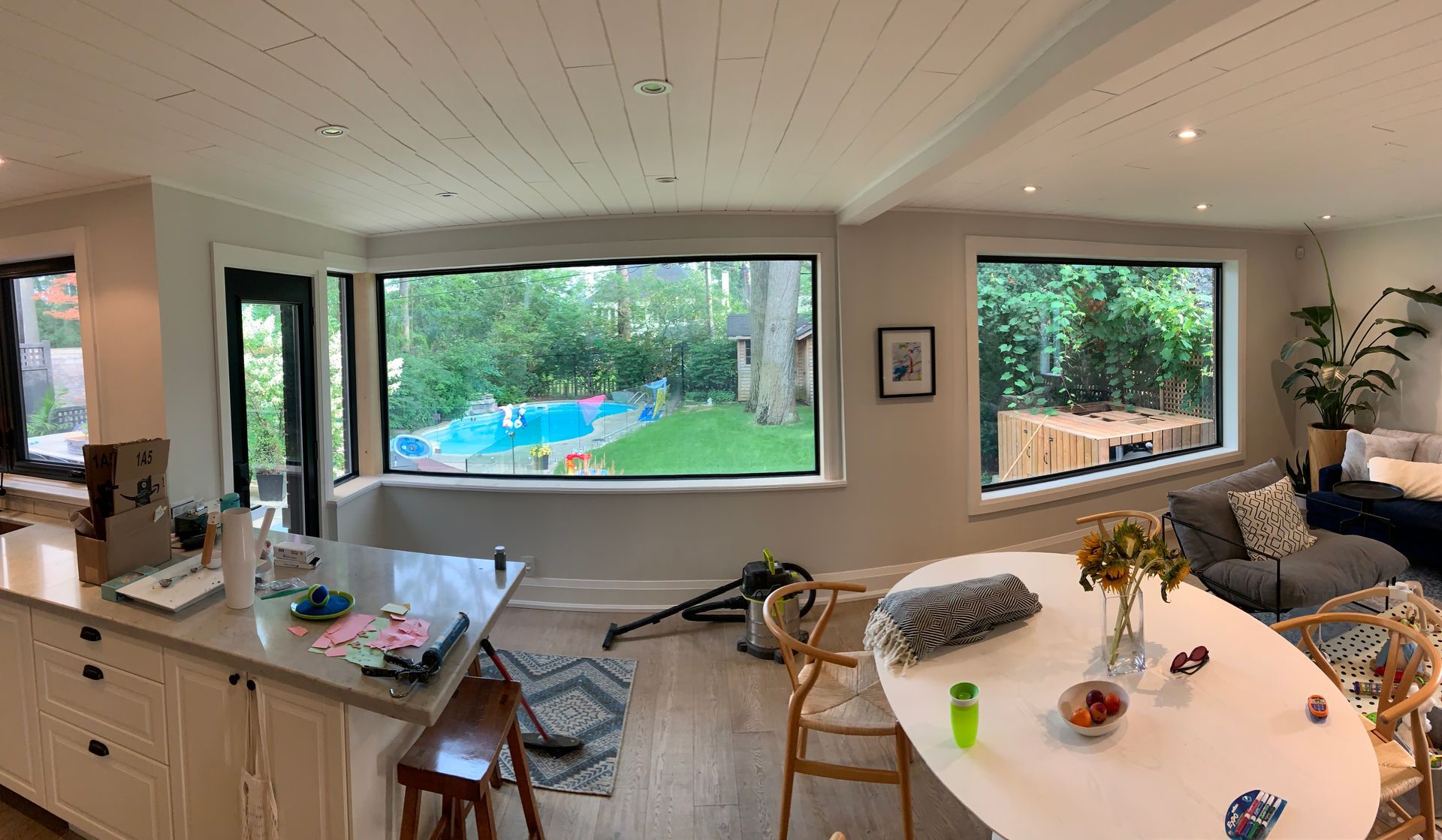 A living room with a table and chairs and a large window.