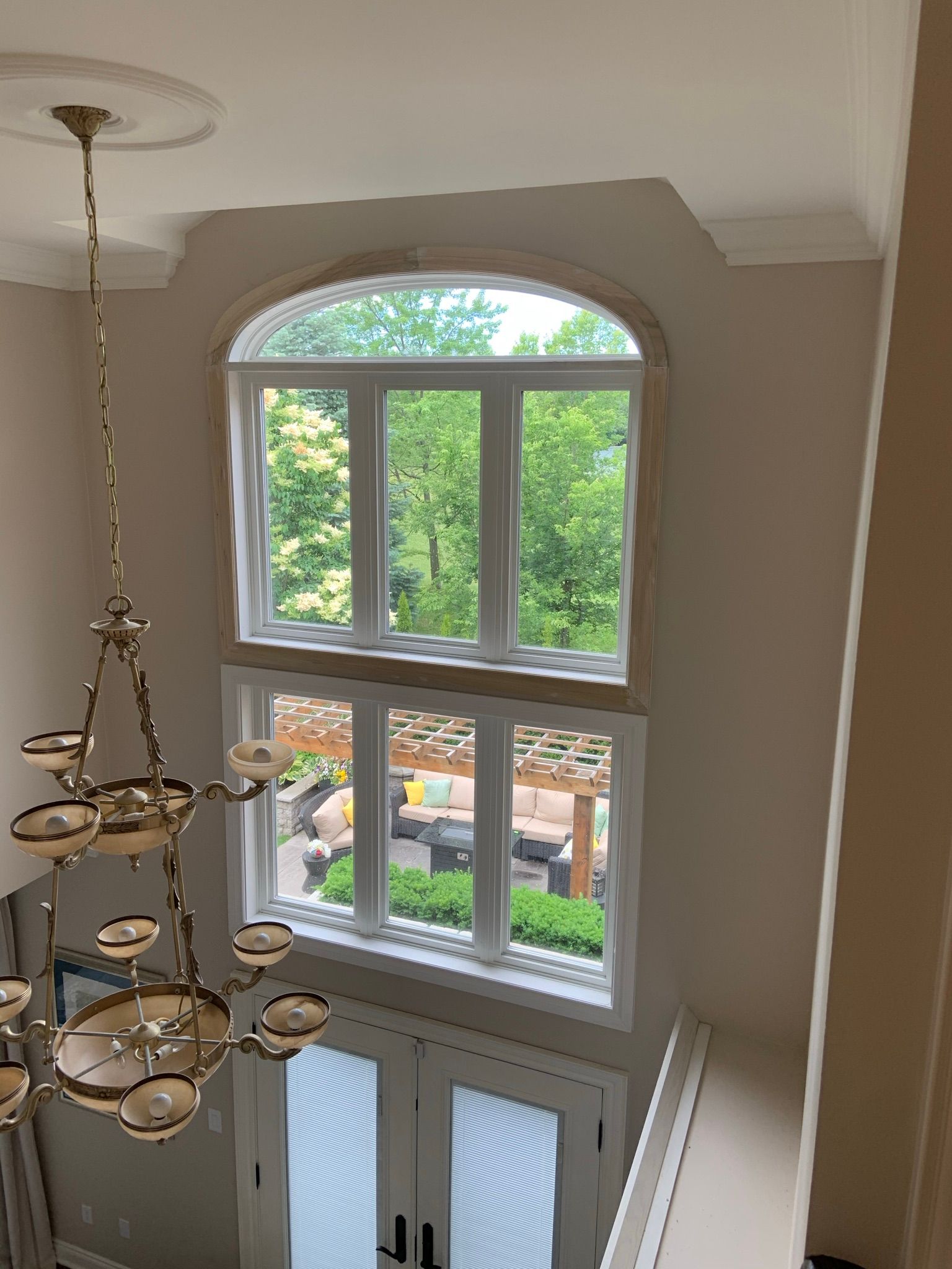 A large window in a room with a chandelier hanging from the ceiling.