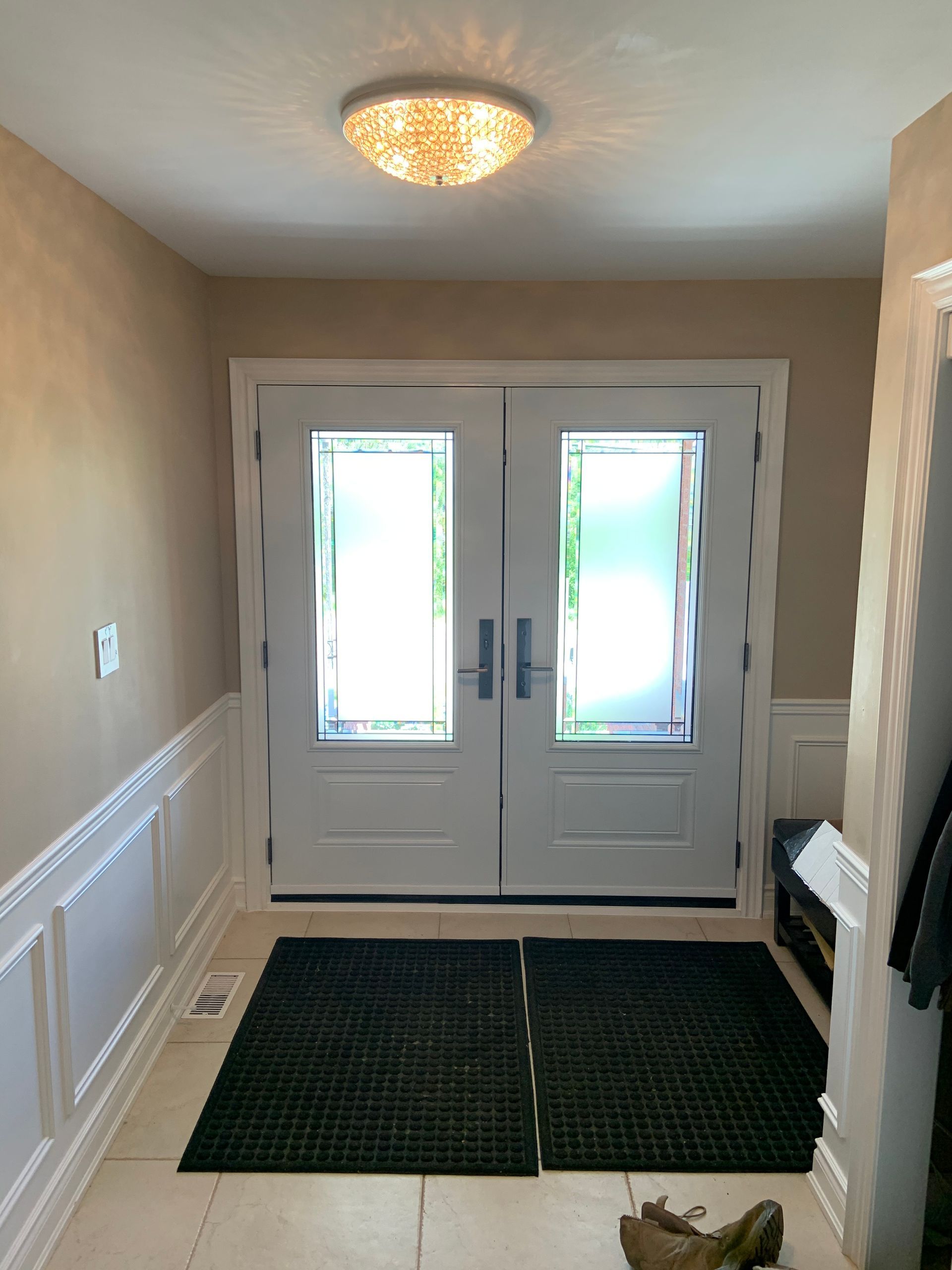 A hallway with two doors and a rug on the floor
