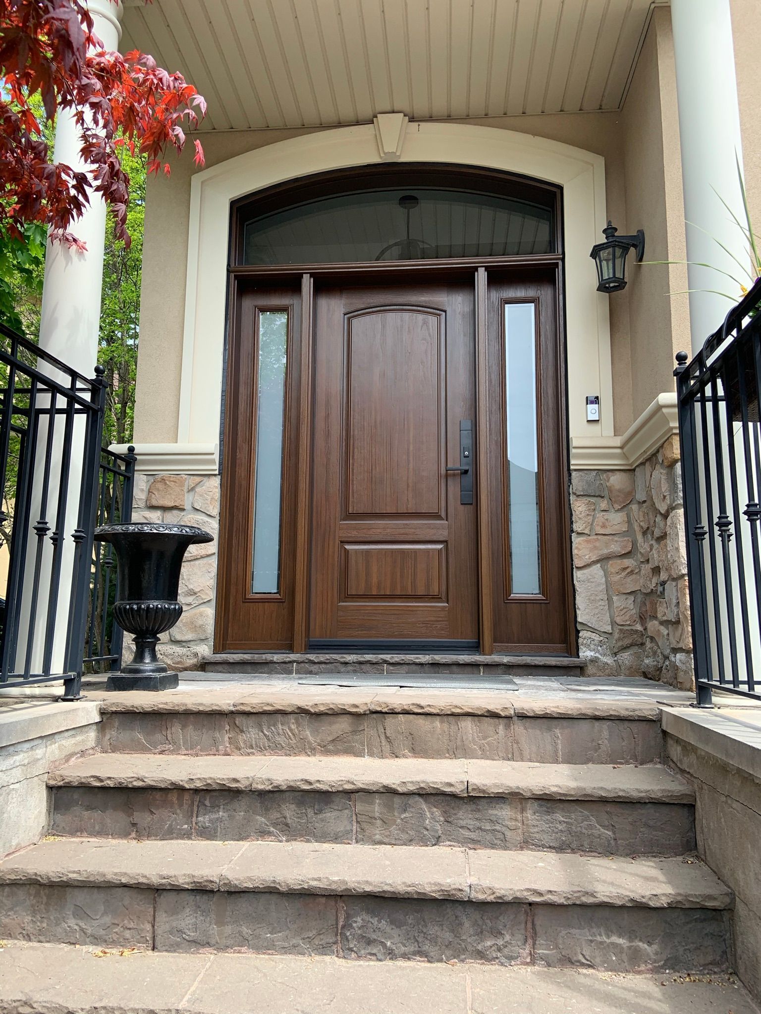 The front door of a house with stairs leading up to it.