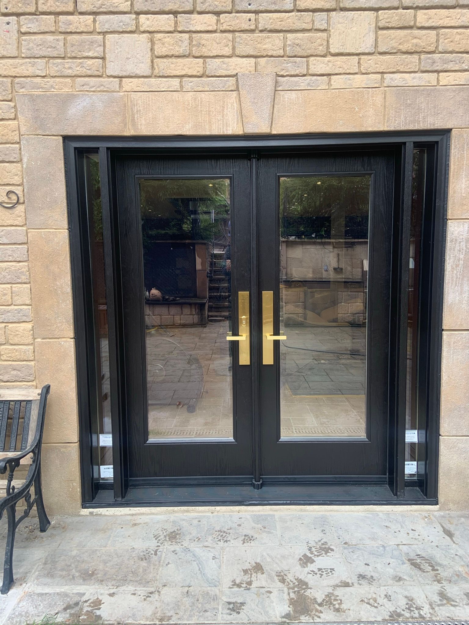 A brick building with a black door and gold handles