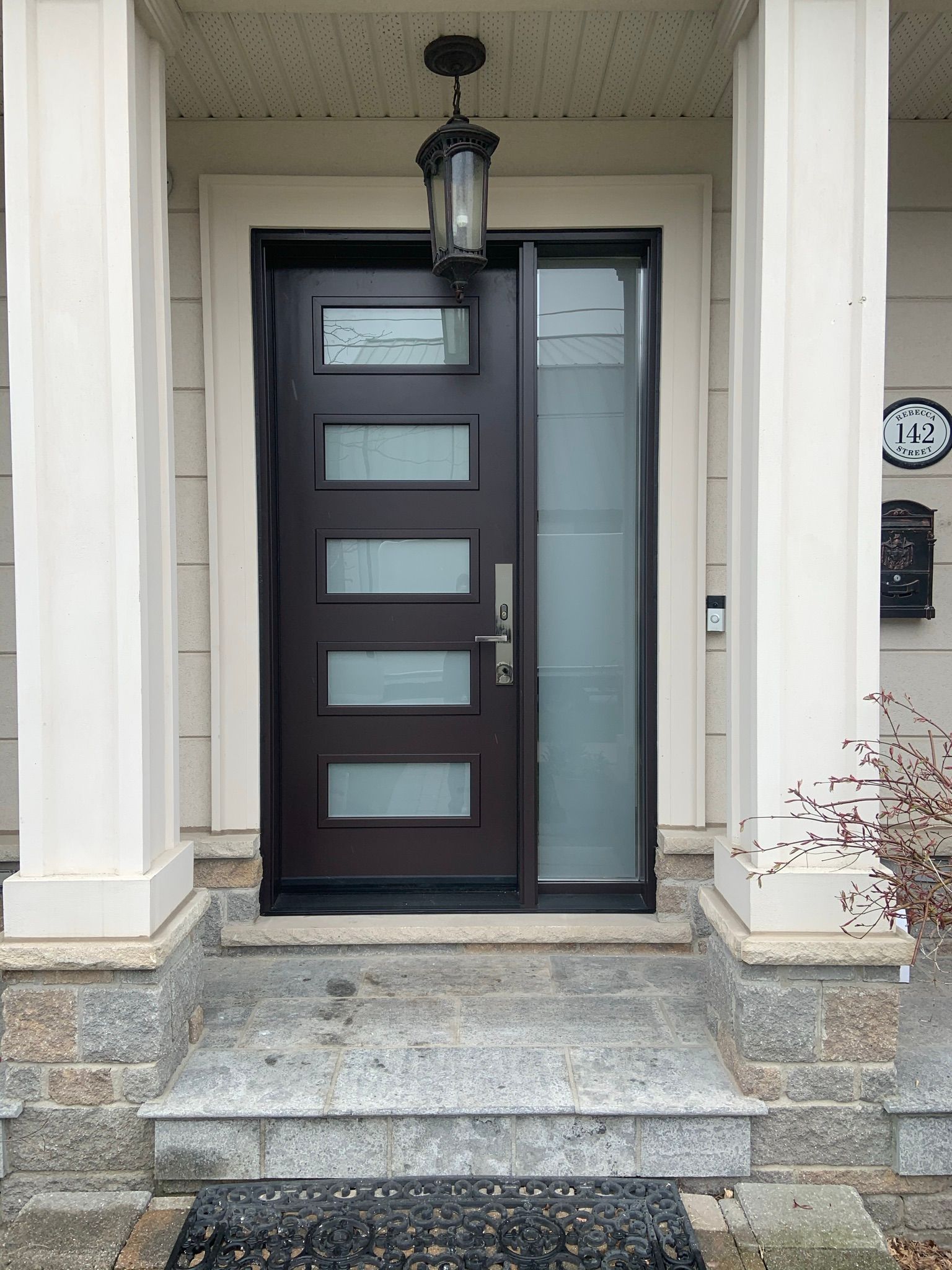 The front door of a house with a lantern hanging from the ceiling.
