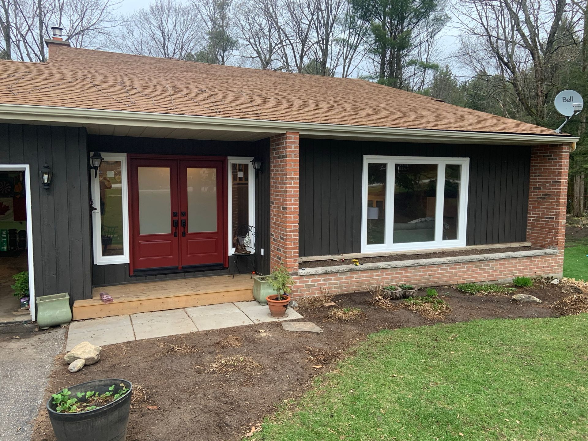 The front of a house with a red door and a brown roof.