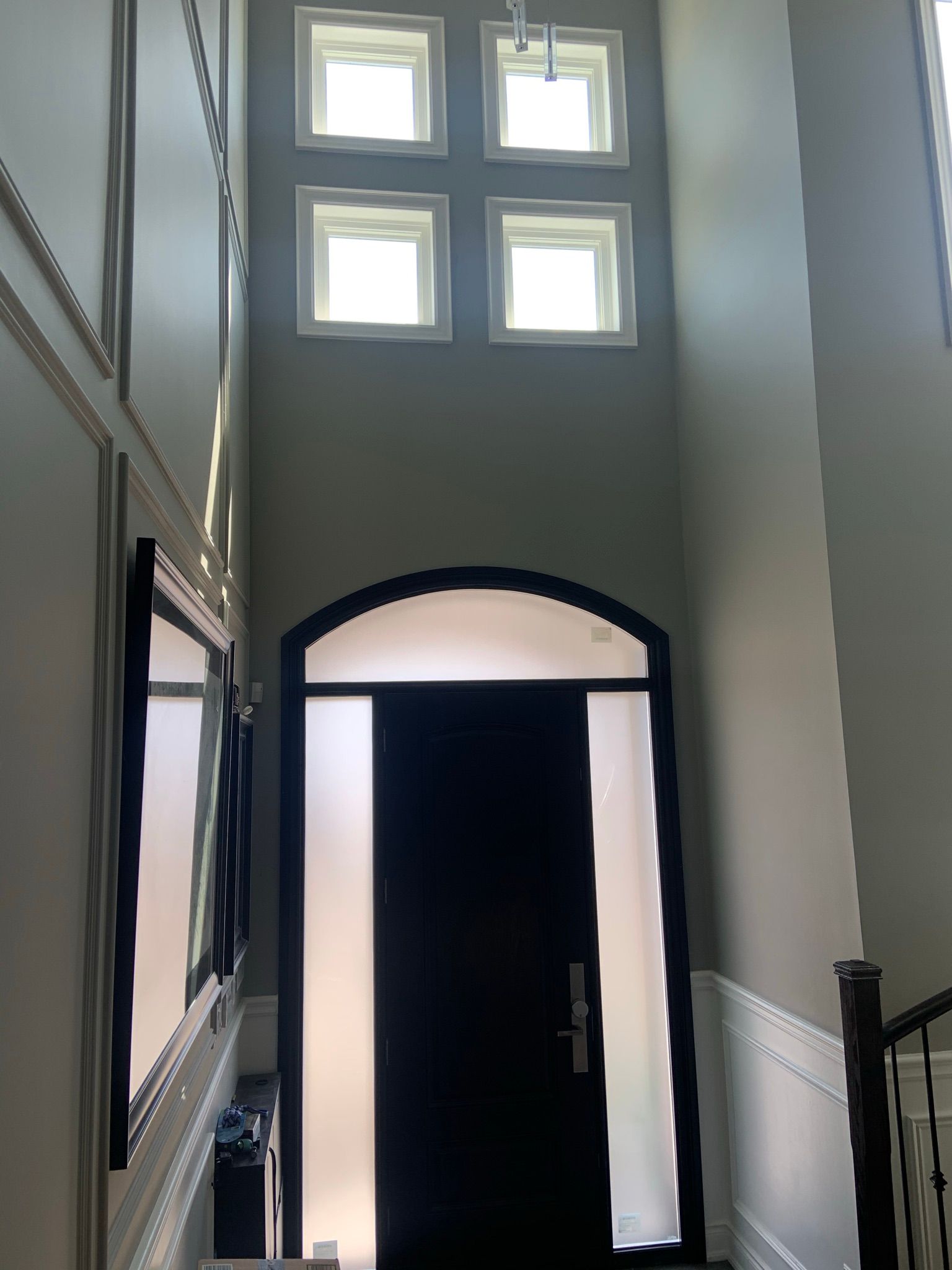 A hallway with a black door and a lot of windows