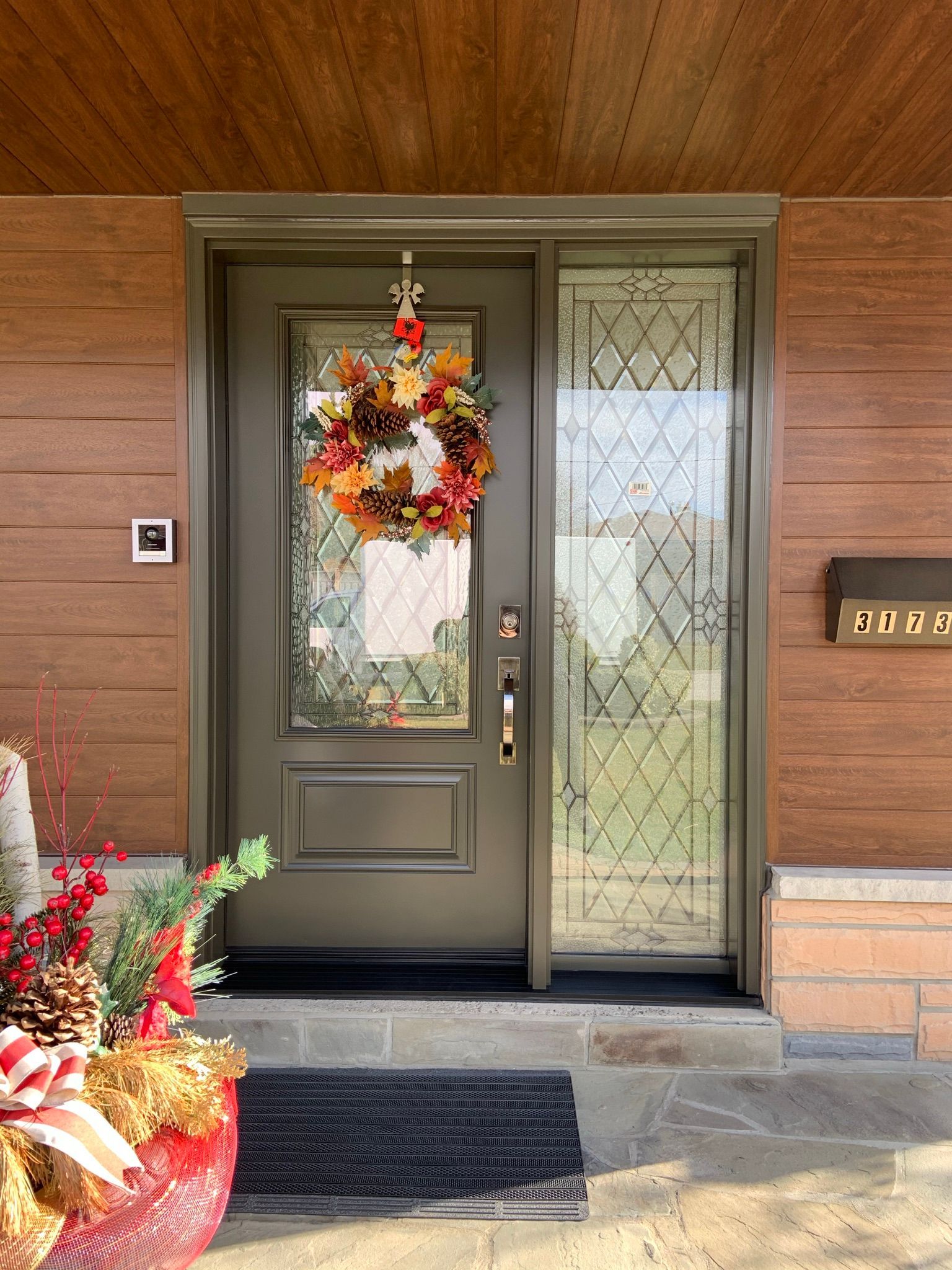 The front door of a house with a wreath hanging from it.