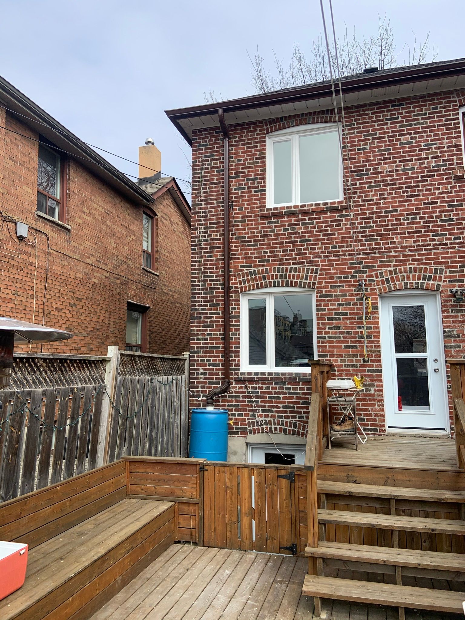 A brick house with a wooden deck in front of it.