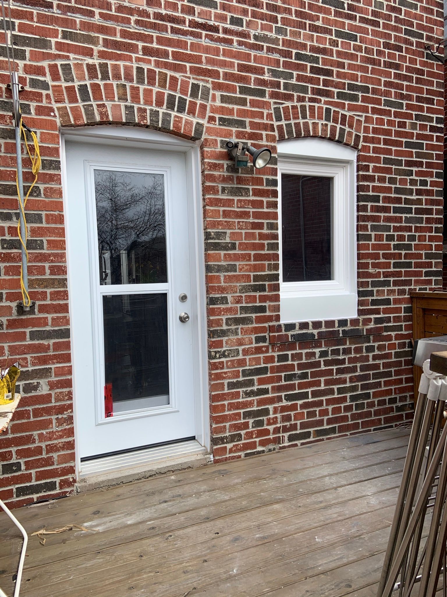 A brick building with a white door and two windows.