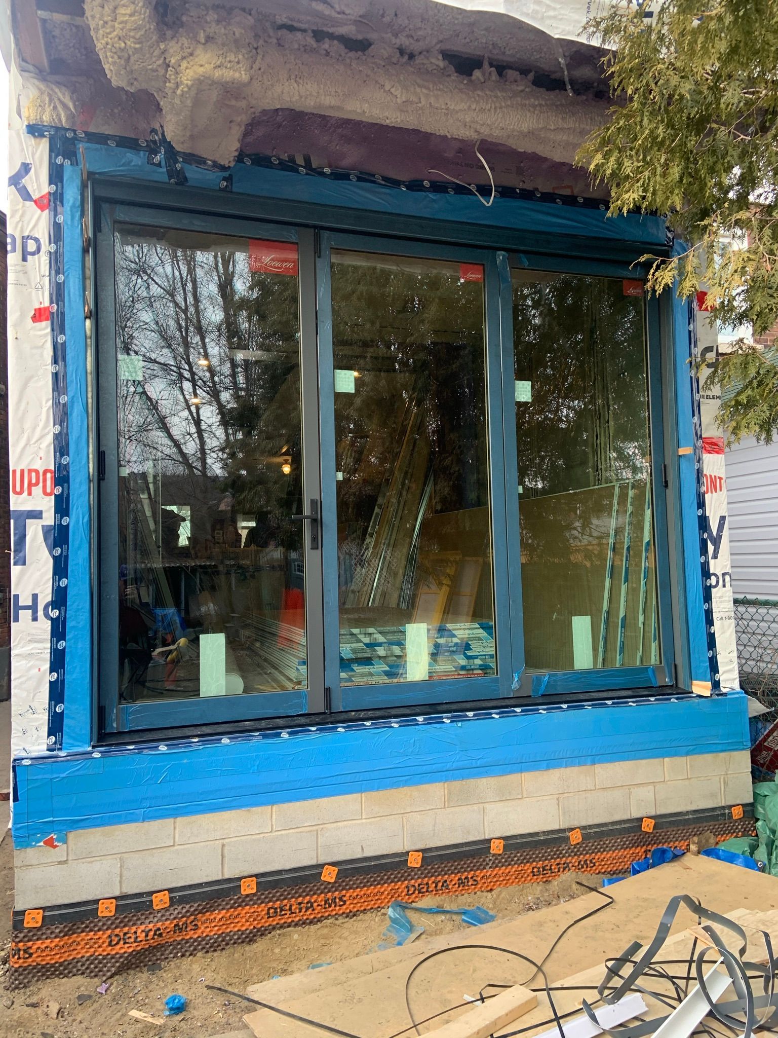 A large window is being installed on the side of a house.