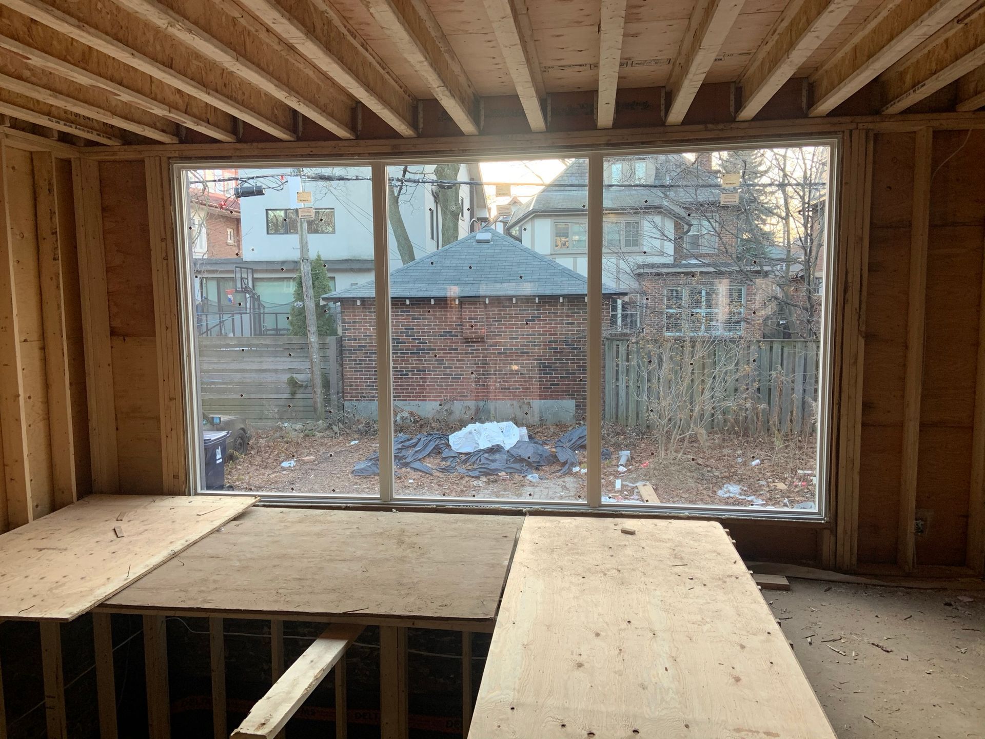 A room in a house under construction with a large window.