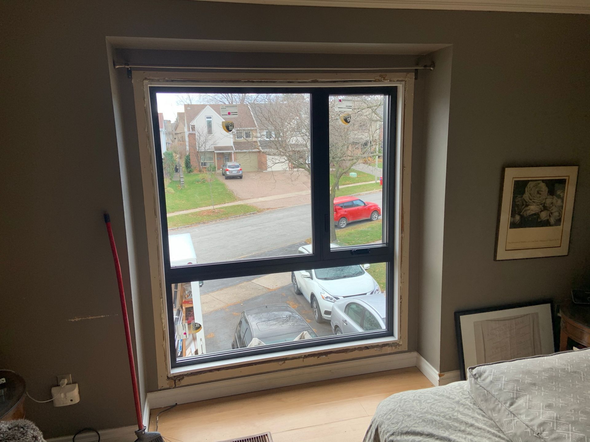 A bedroom with a large window and a bed.