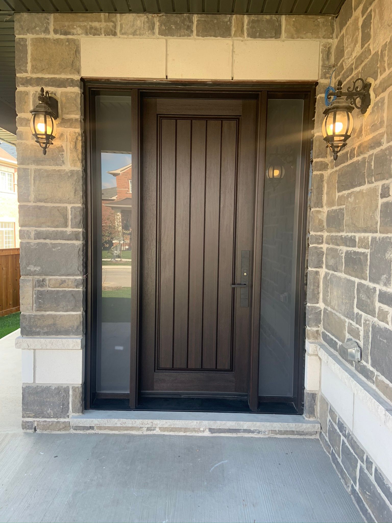 The front door of a brick house with a wooden door