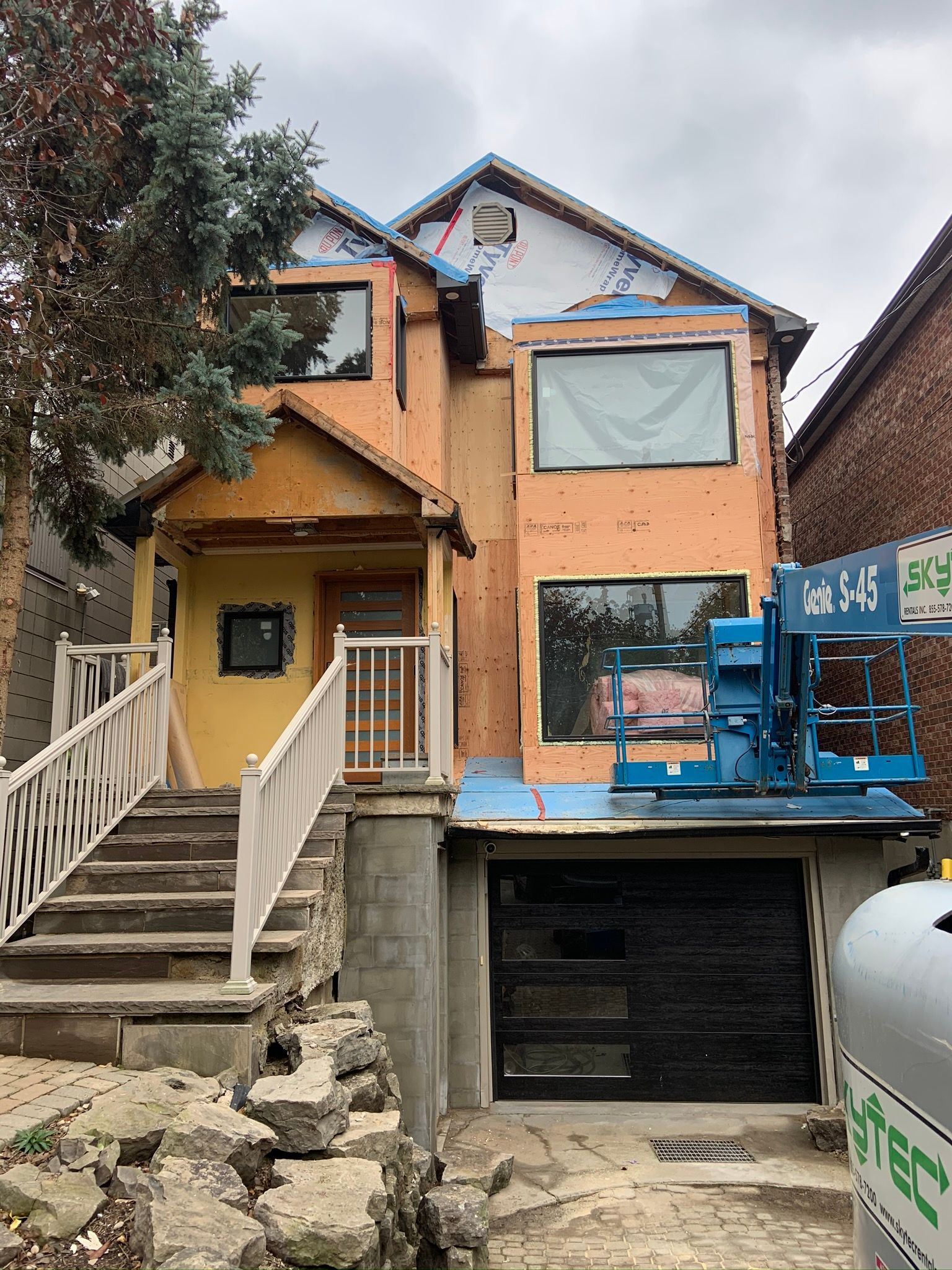 A house is being remodeled with a crane in front of it.