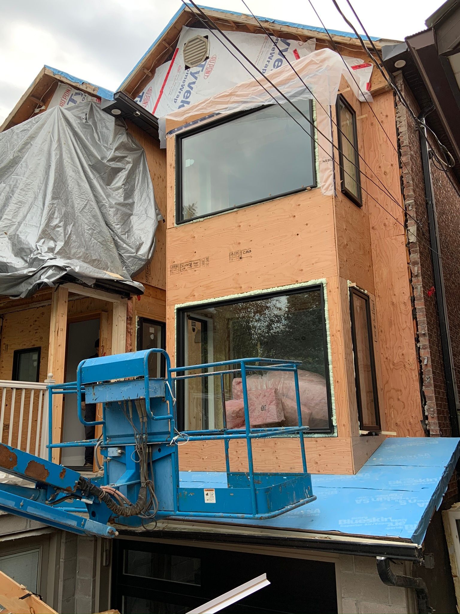 A house is being built with a crane on top of it.