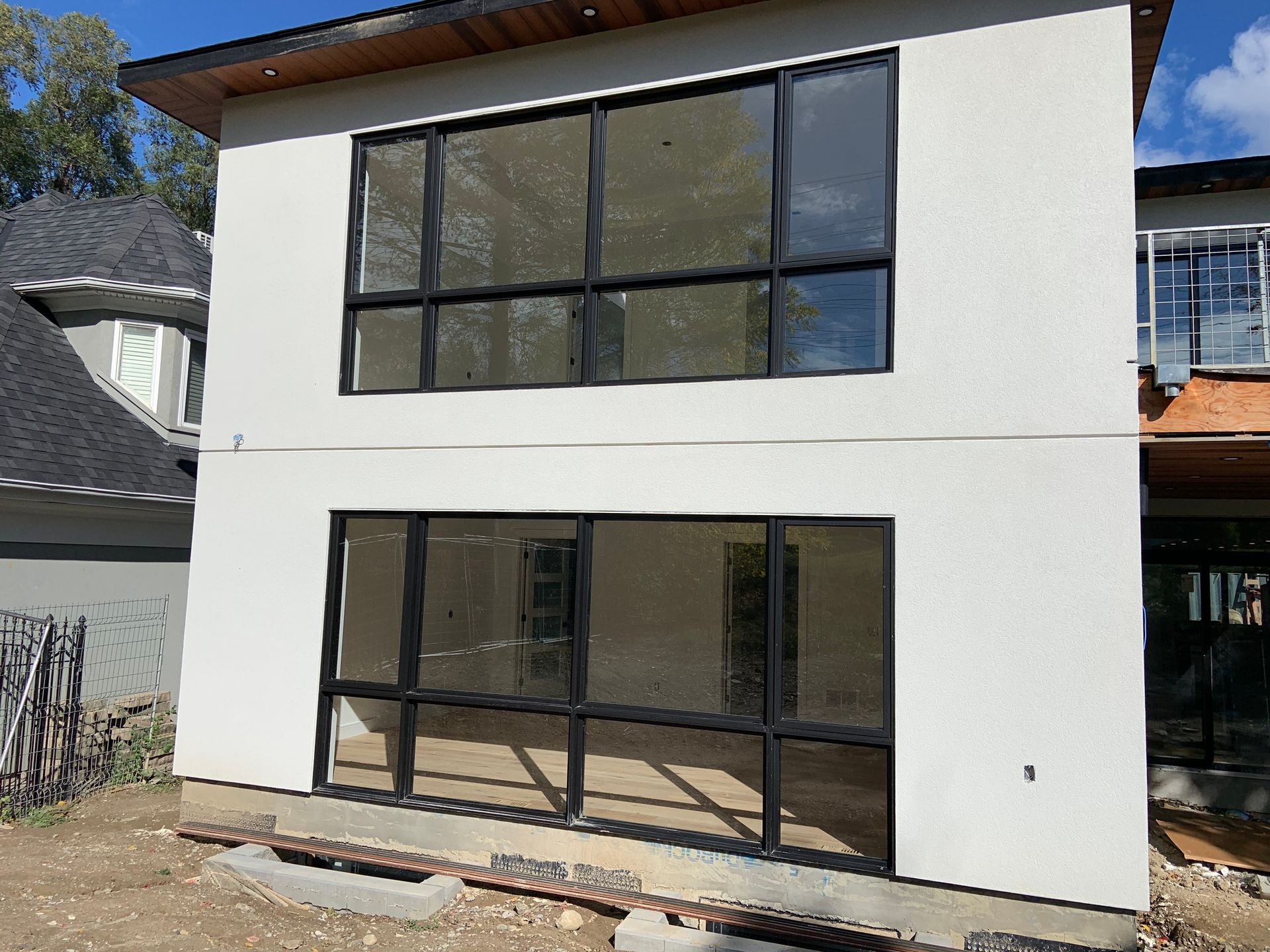 A white house with a lot of windows is being built.