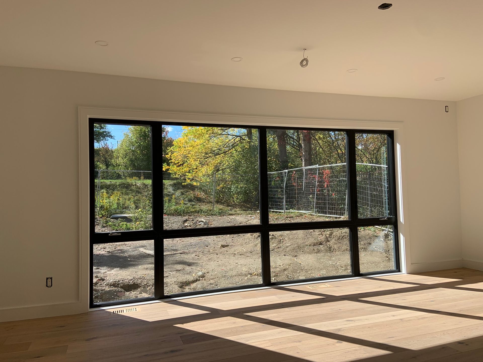 An empty room with a lot of windows and a wooden floor.