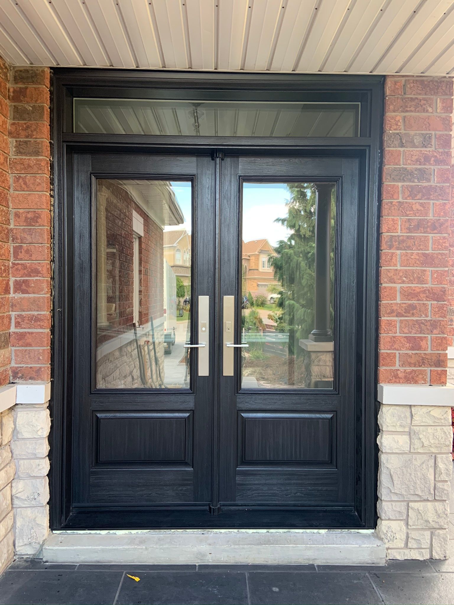 A pair of black double doors on a brick building.