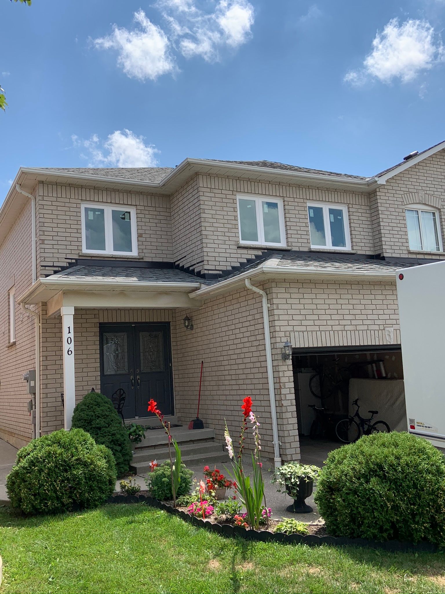 A large brick house with a white truck parked in front of it.