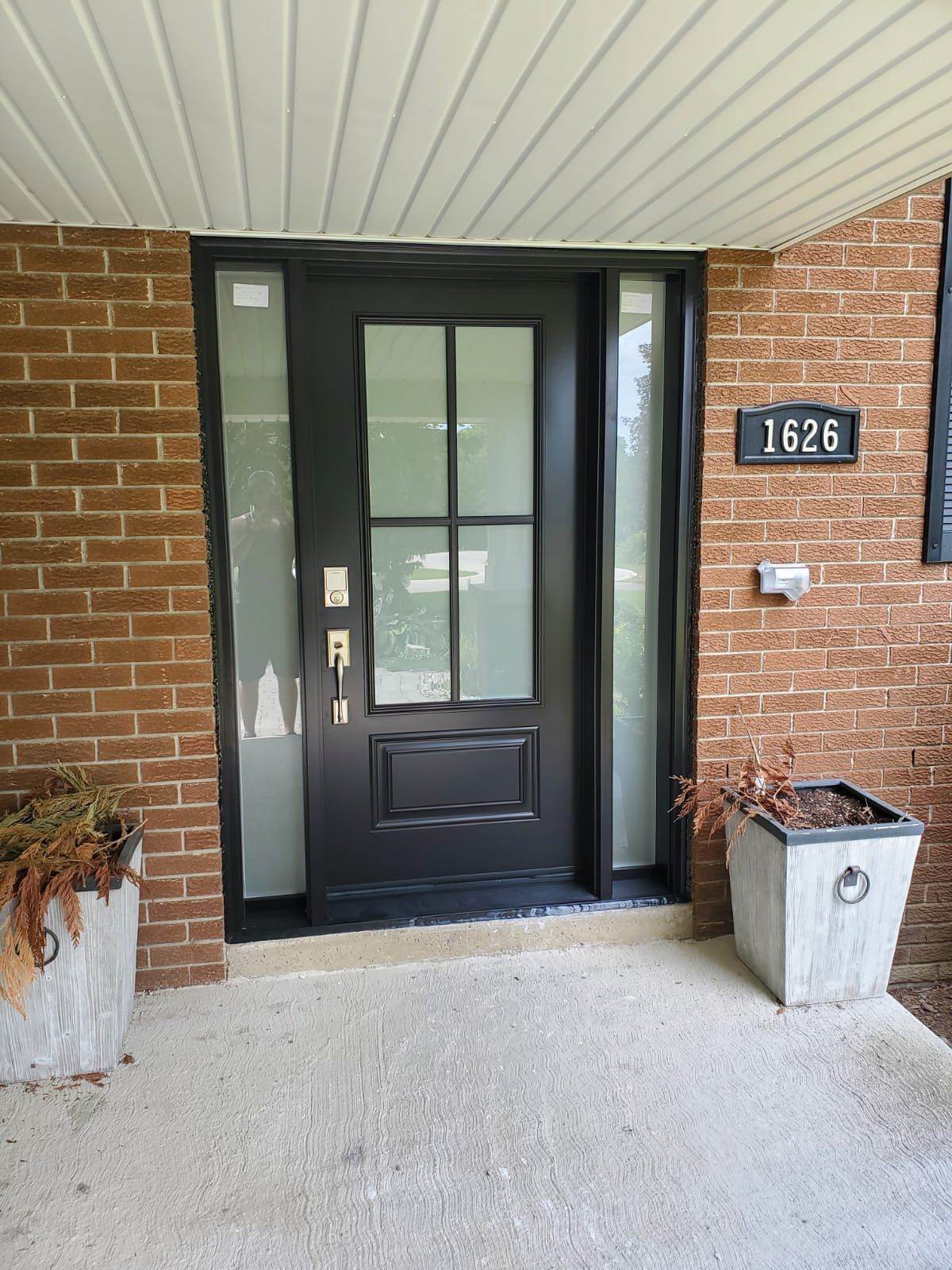 The front door of a brick house with a black door