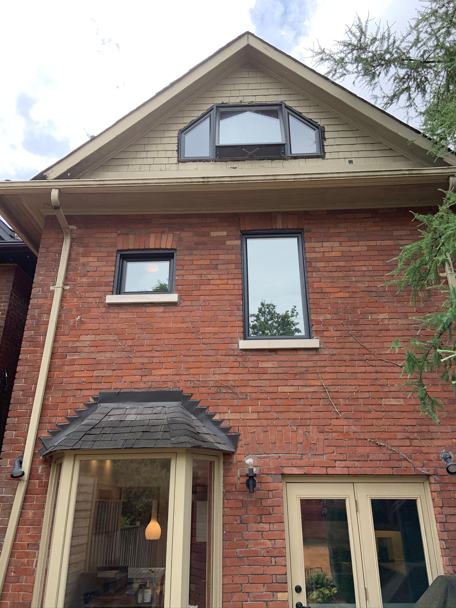 A brick house with a lot of windows and a roof