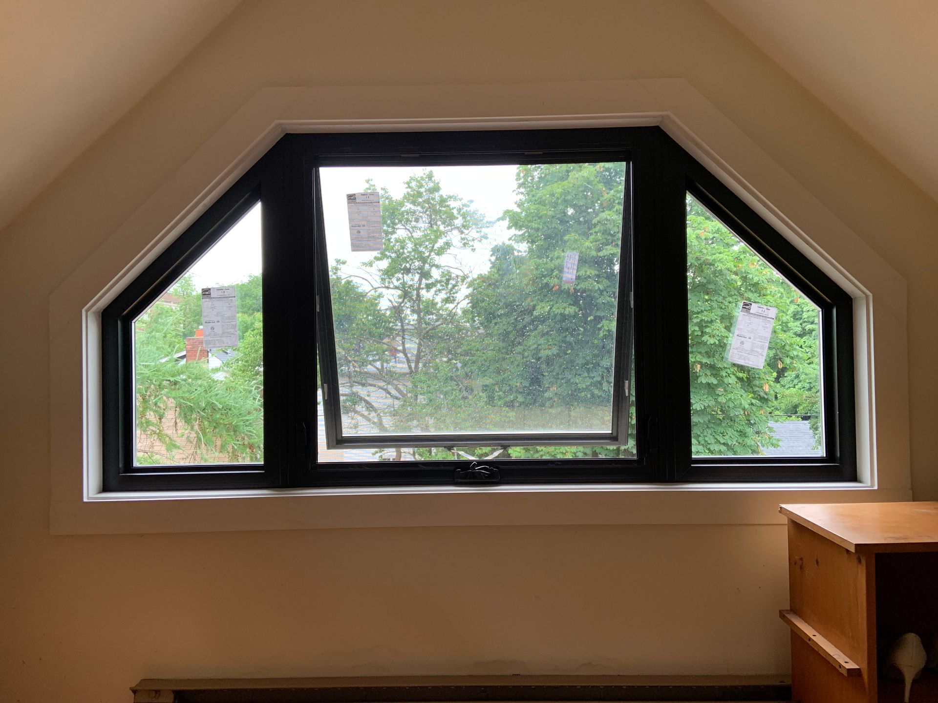 There is a window in the attic with a view of the trees.