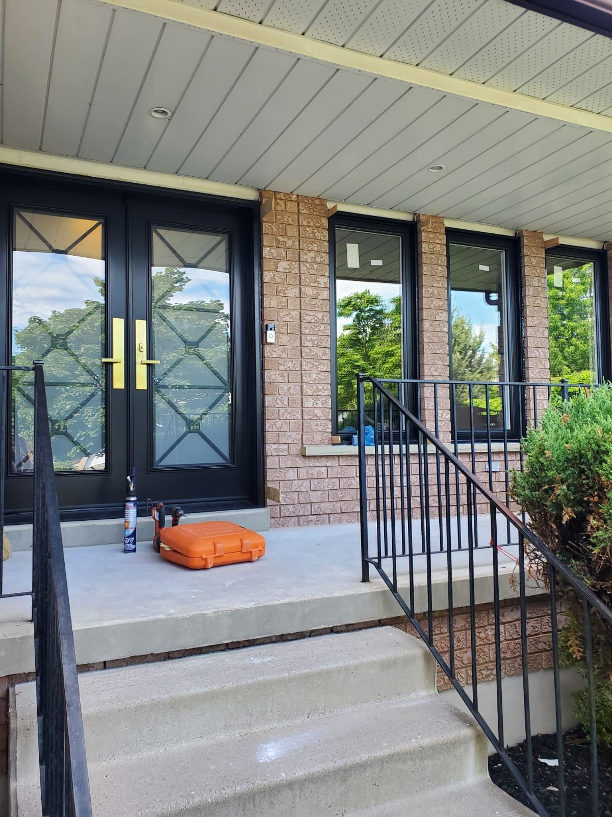 A brick house with a black door and stairs