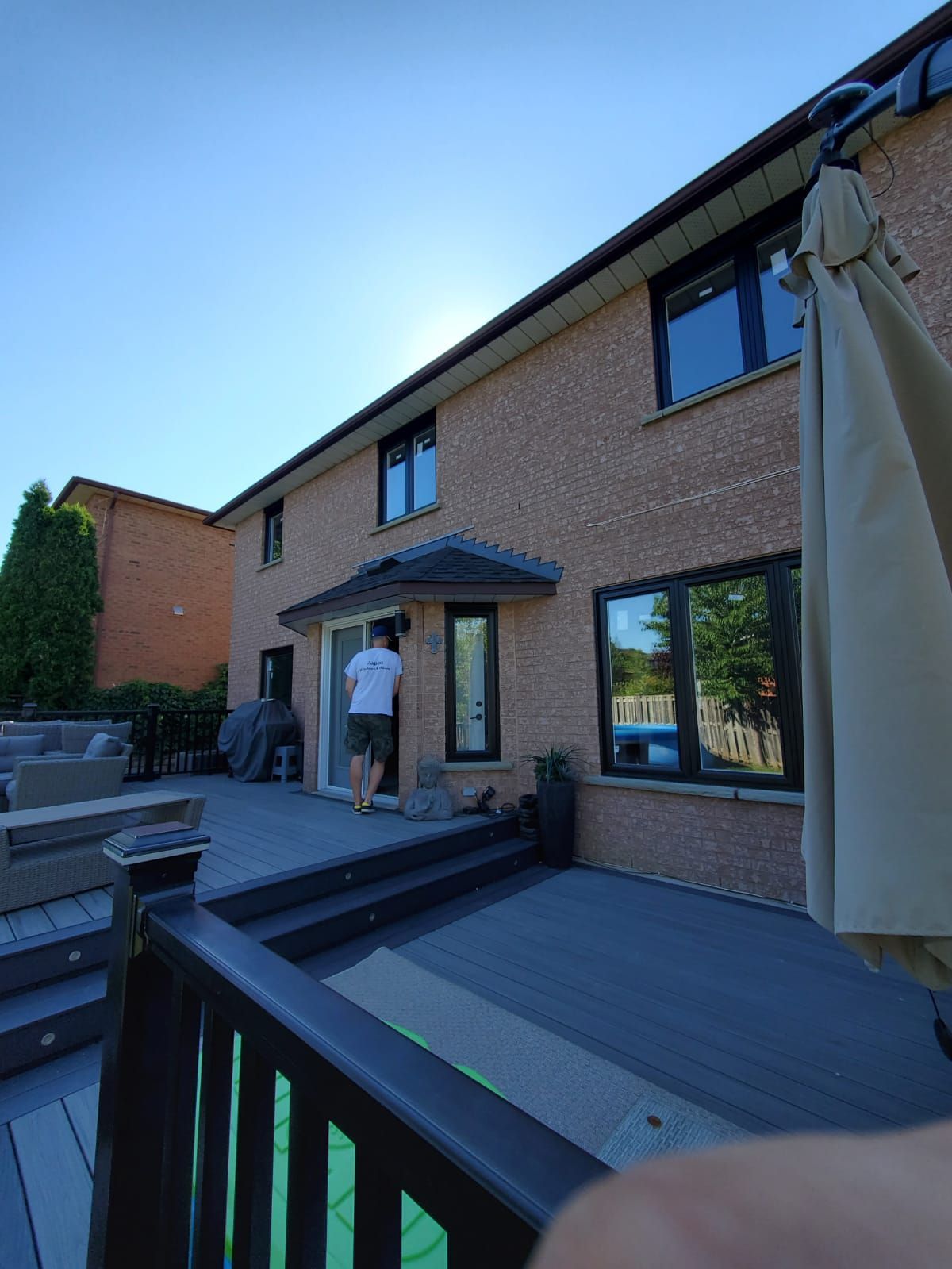 A man standing on a deck in front of a house