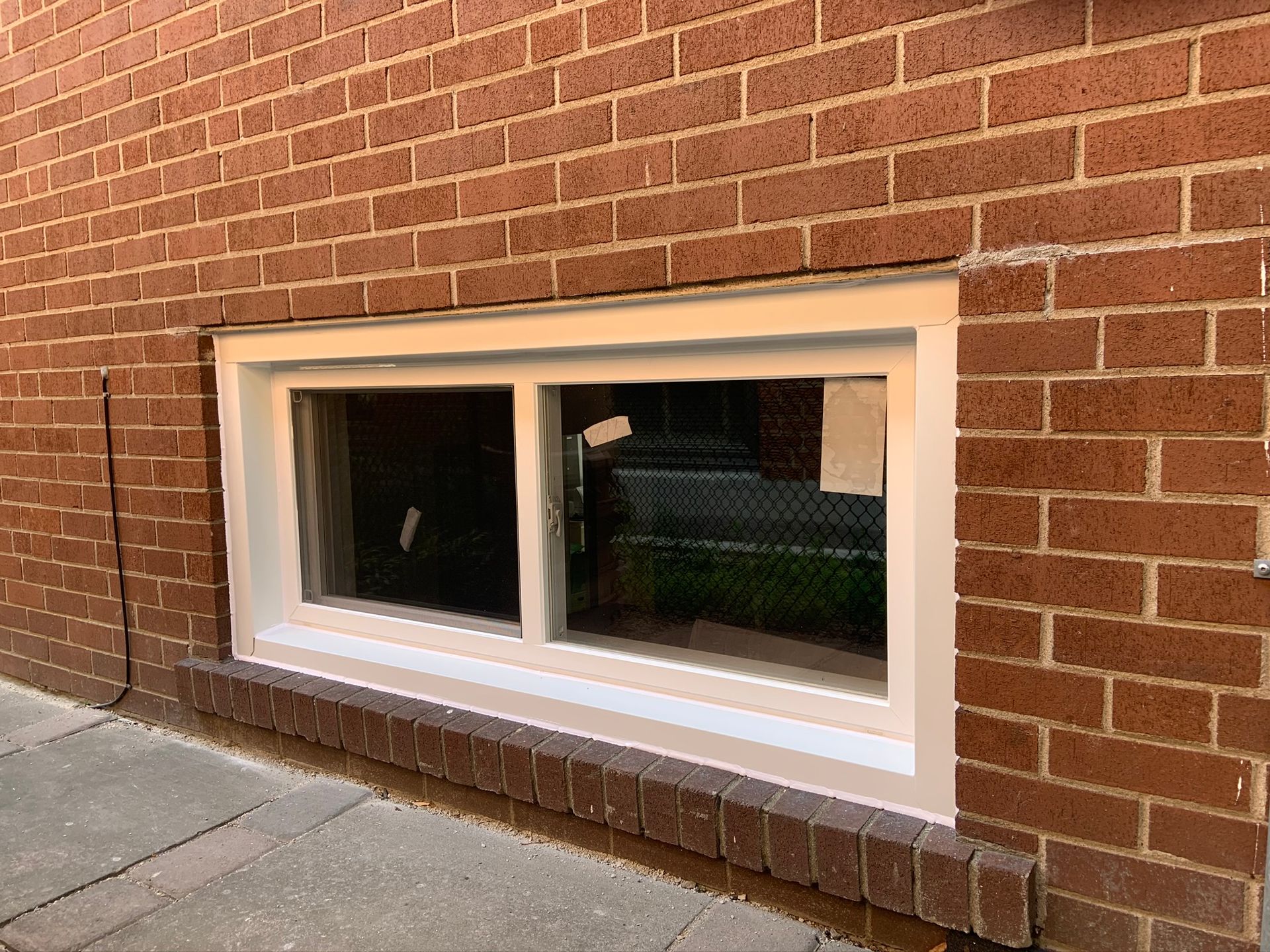 A brick wall with a white window on it.