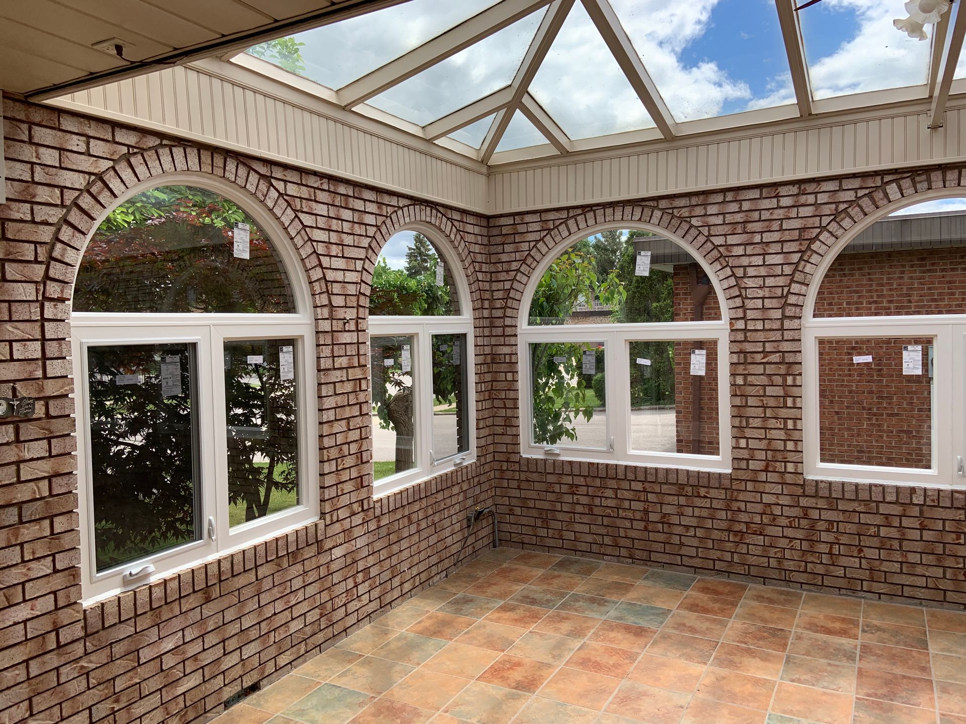 An empty room with brick walls and arched windows.