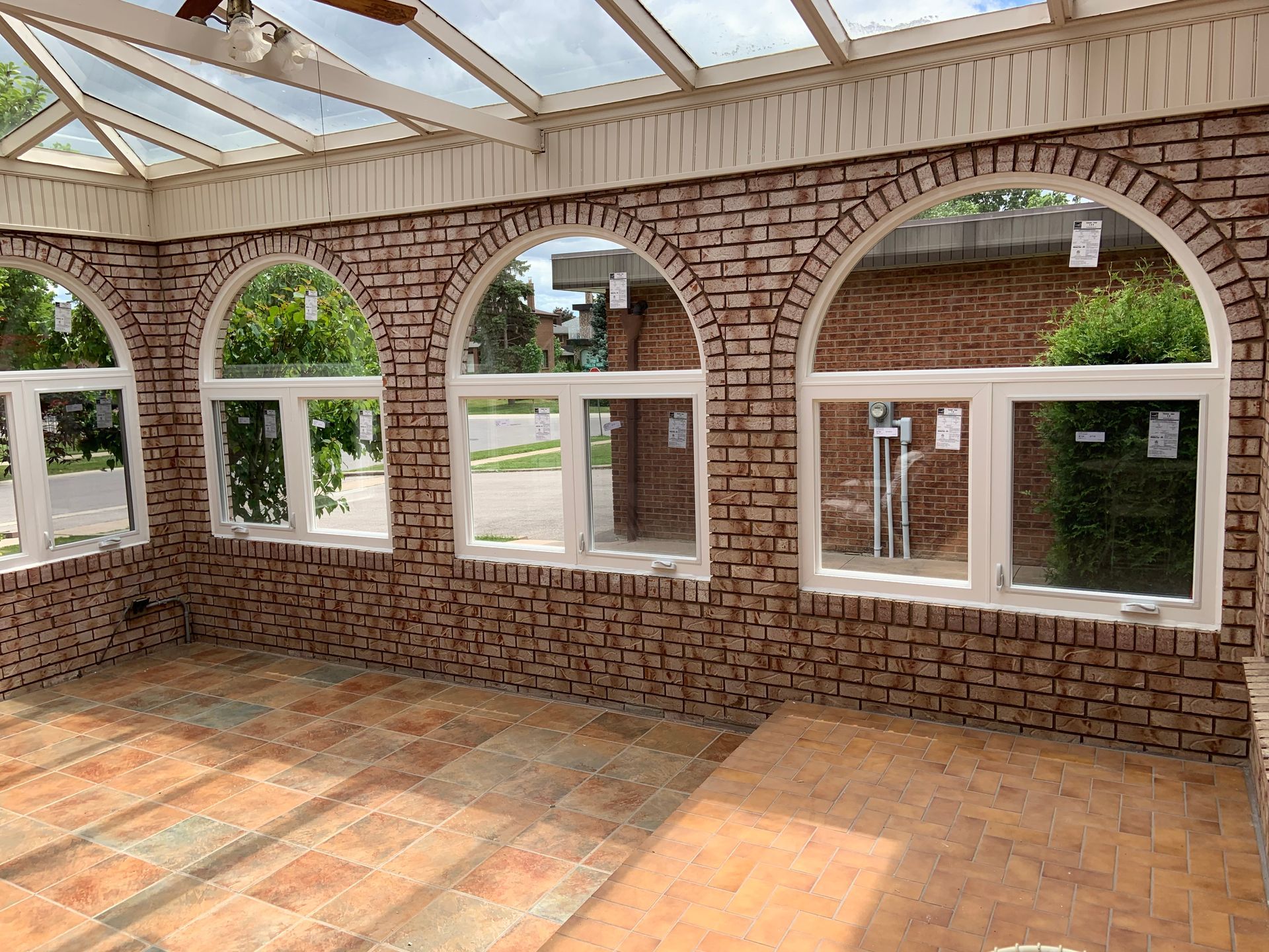 An empty room with arched windows and a brick wall.