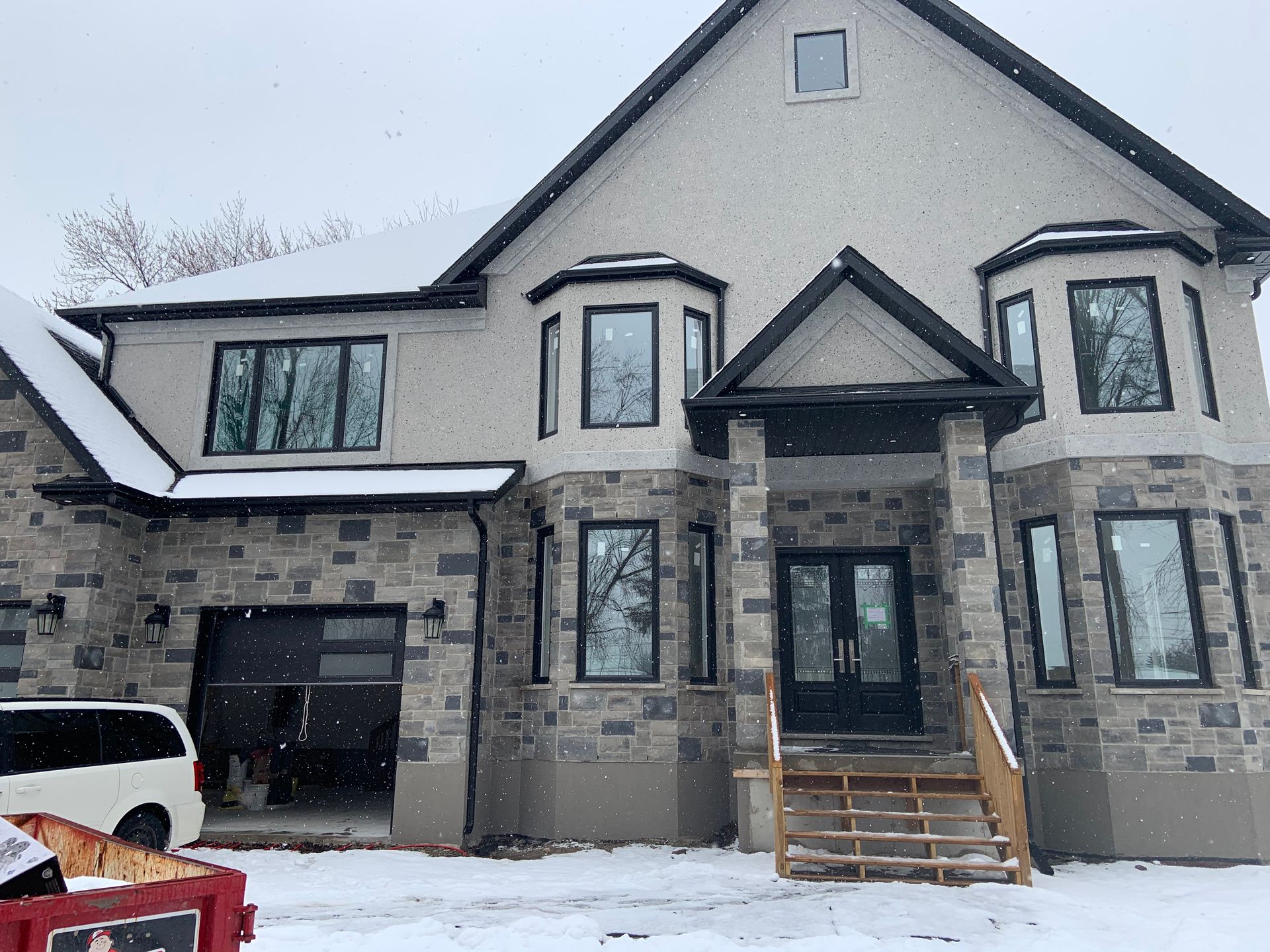 A large house with a lot of windows is covered in snow.