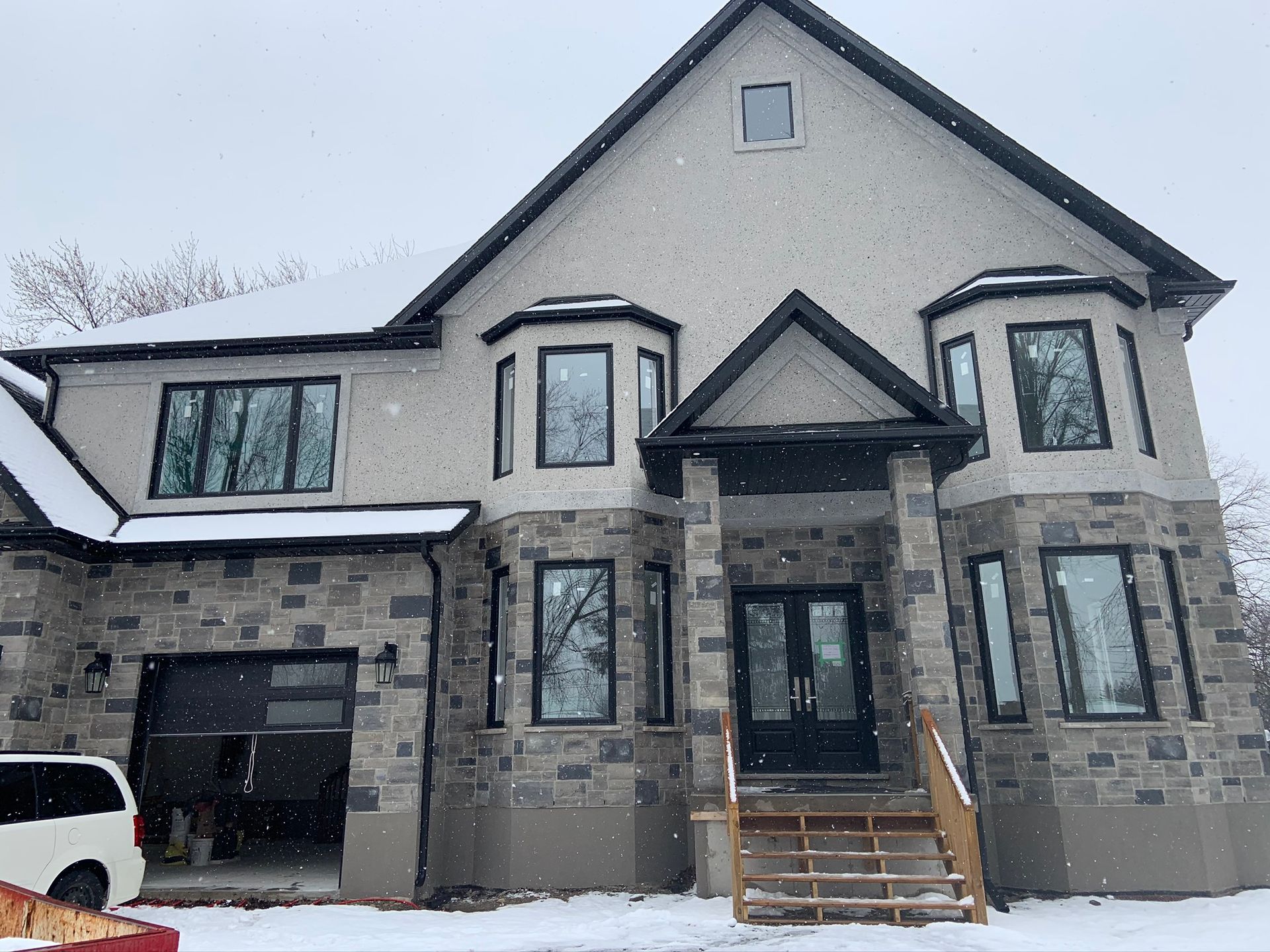 A large house with a truck parked in front of it in the snow.