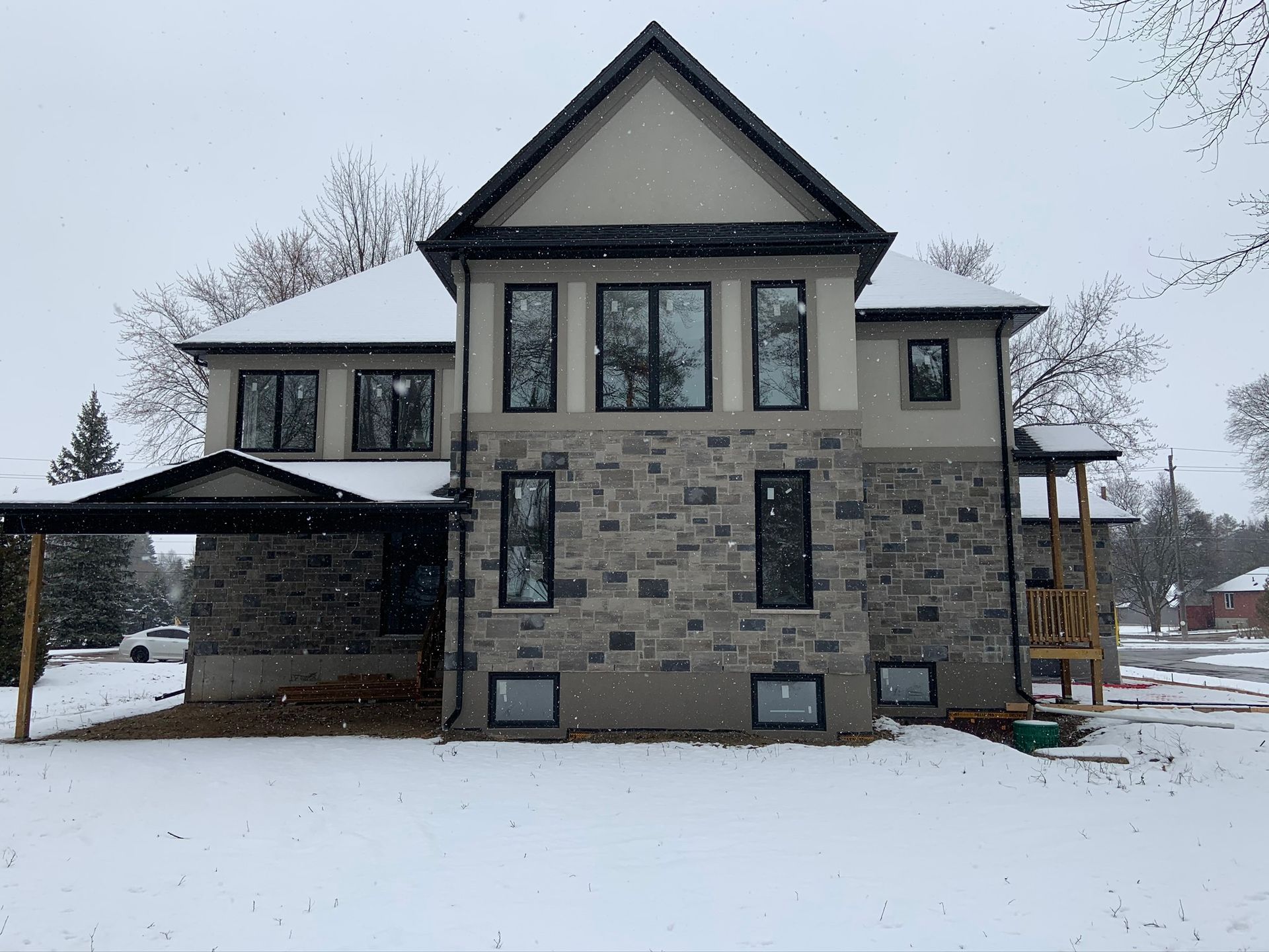 A large house with a lot of windows is covered in snow.