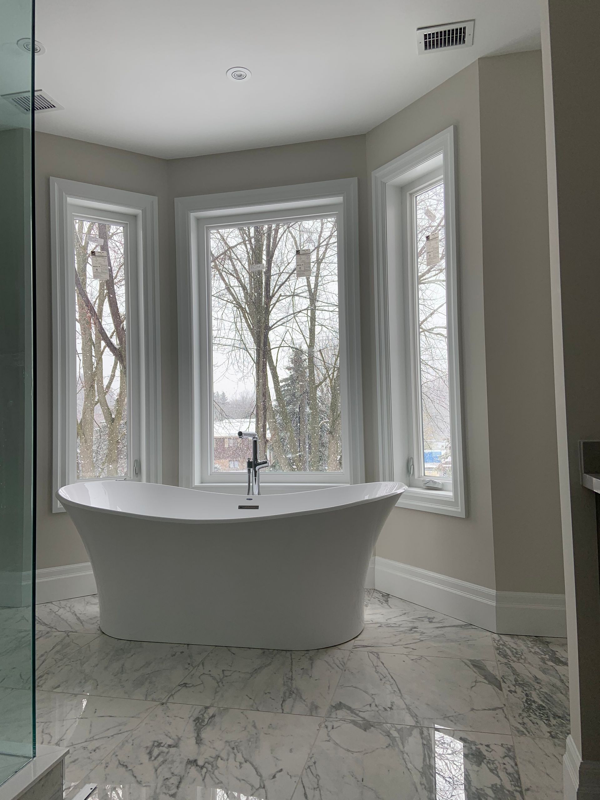 A bathtub in a bathroom with a lot of windows